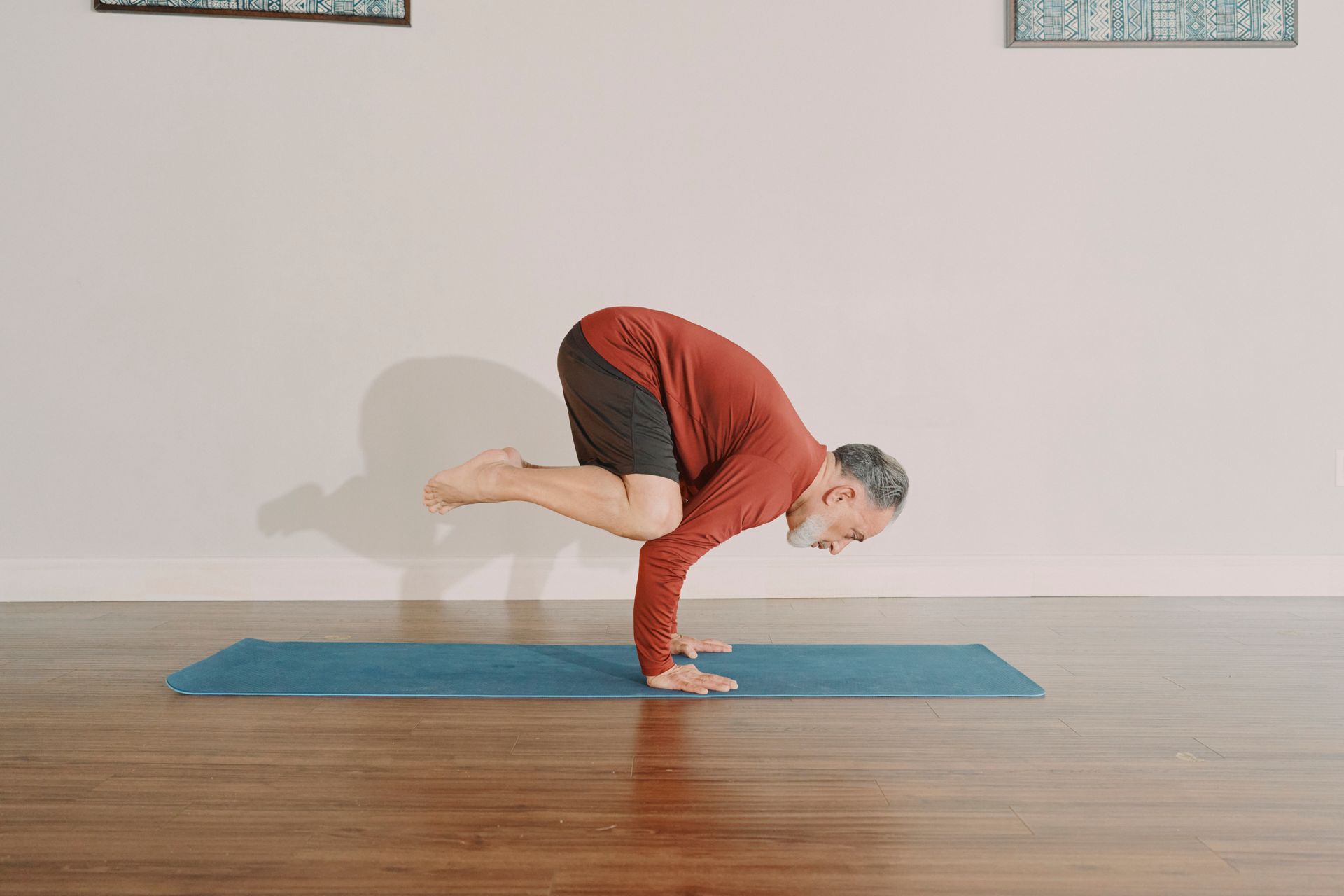 Person balancing on hands in yoga pose on a mat in a minimalist room