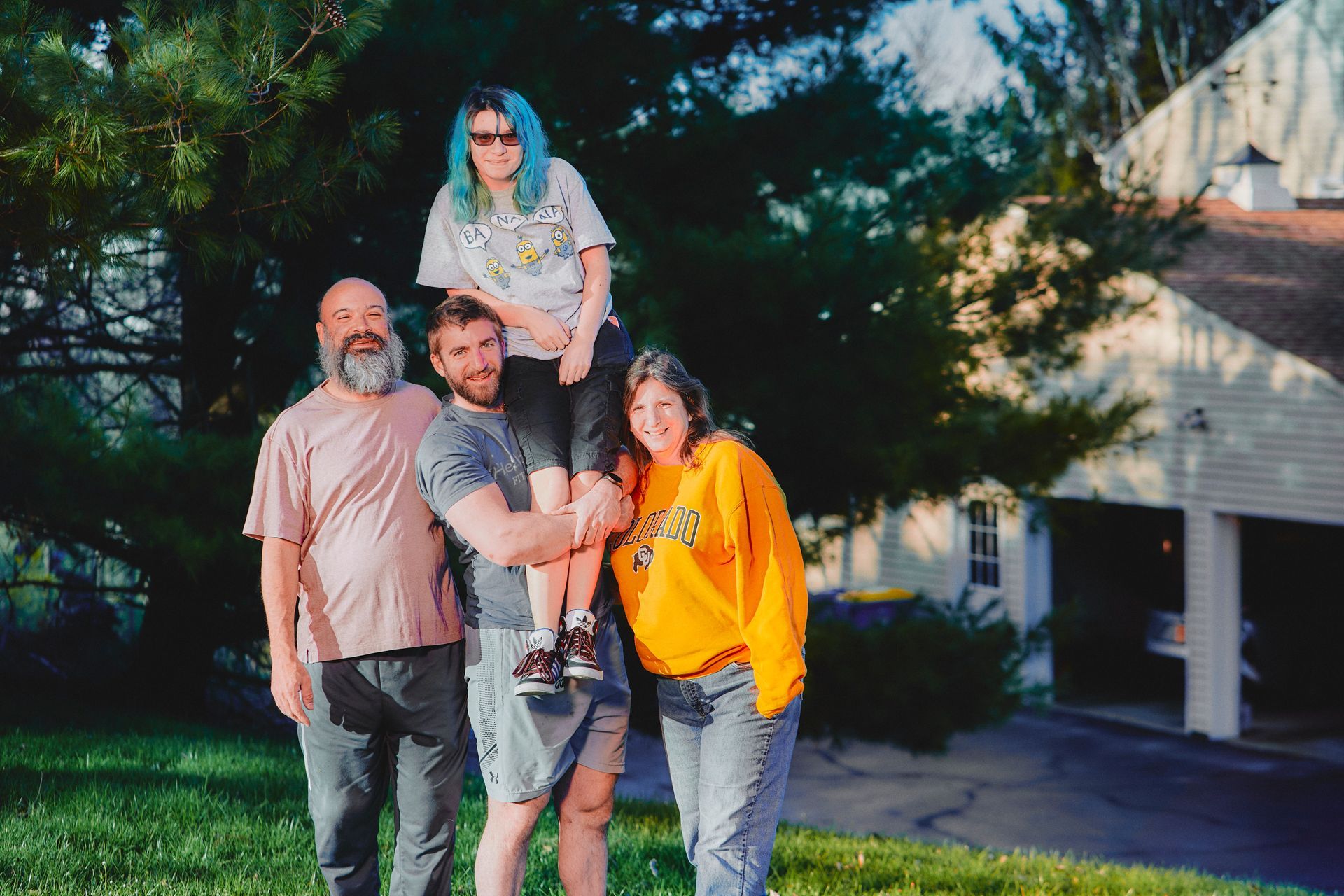 A group of people are posing for a picture in front of a house.
