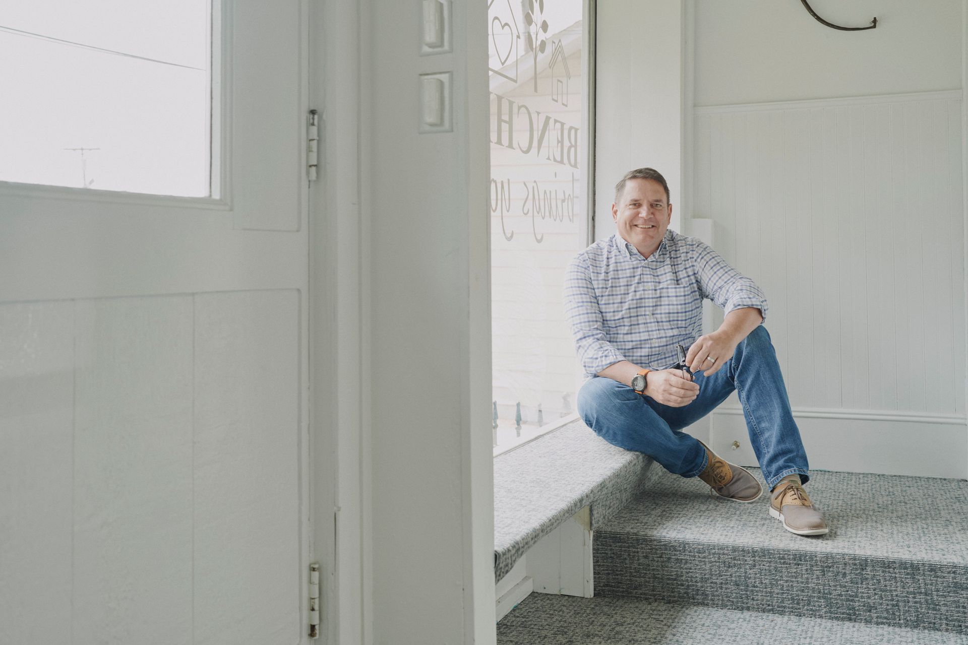 A man is sitting on the steps of a building.