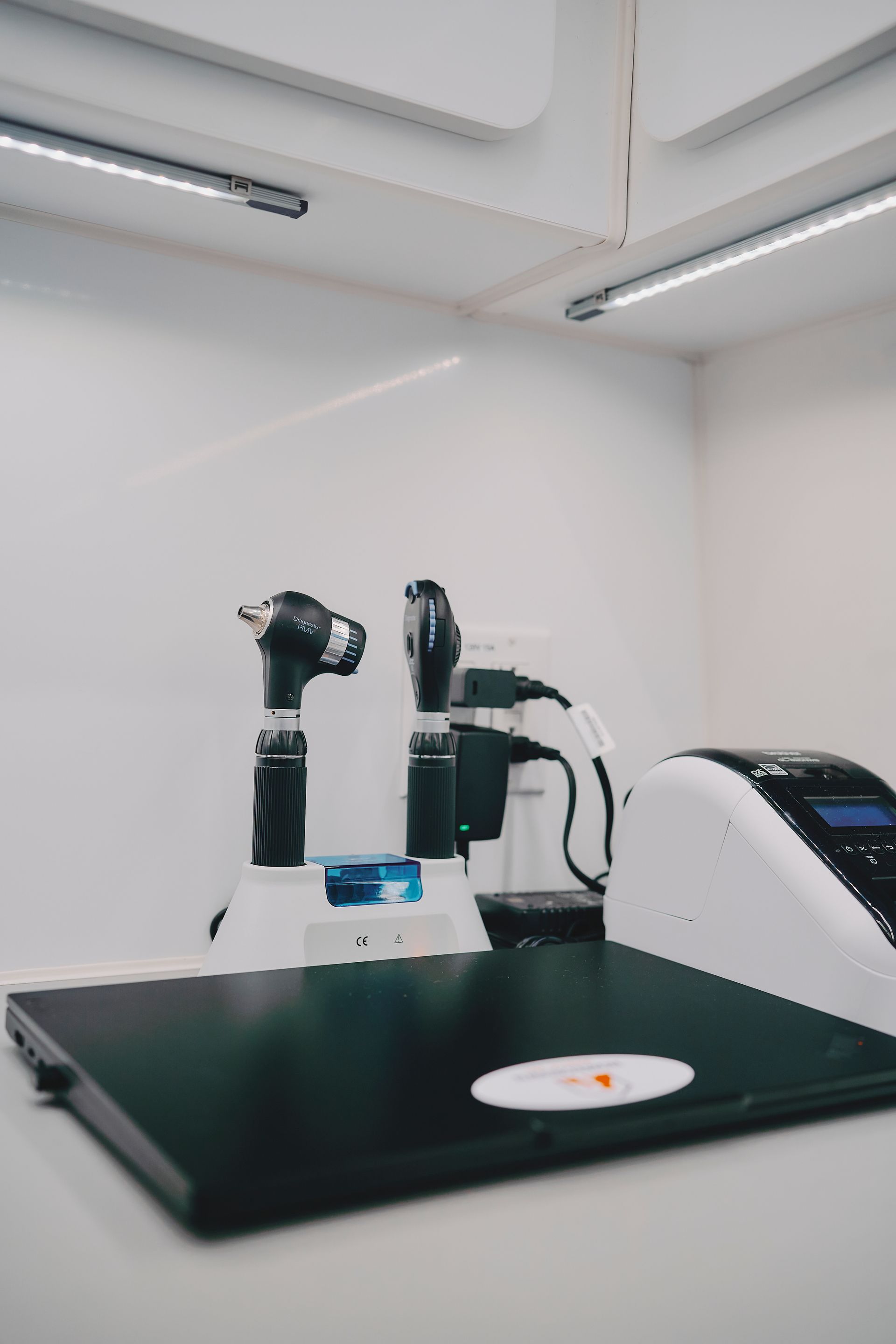 Laboratory workstation with two robotic arms and a petri dish on a black table under bright lights