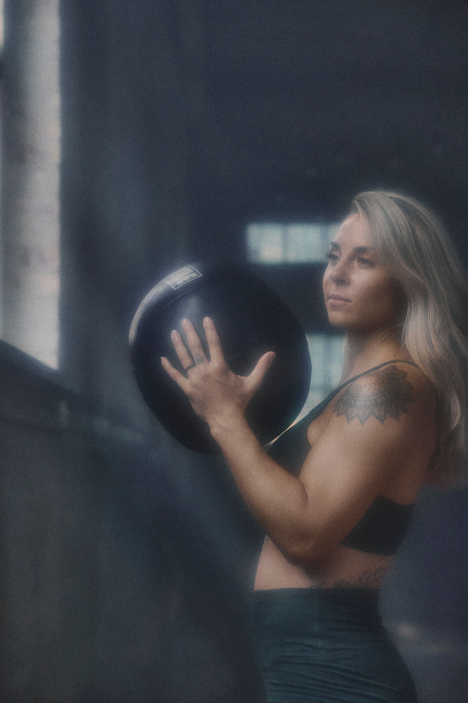 A woman is holding a ball in her hand in a gym.