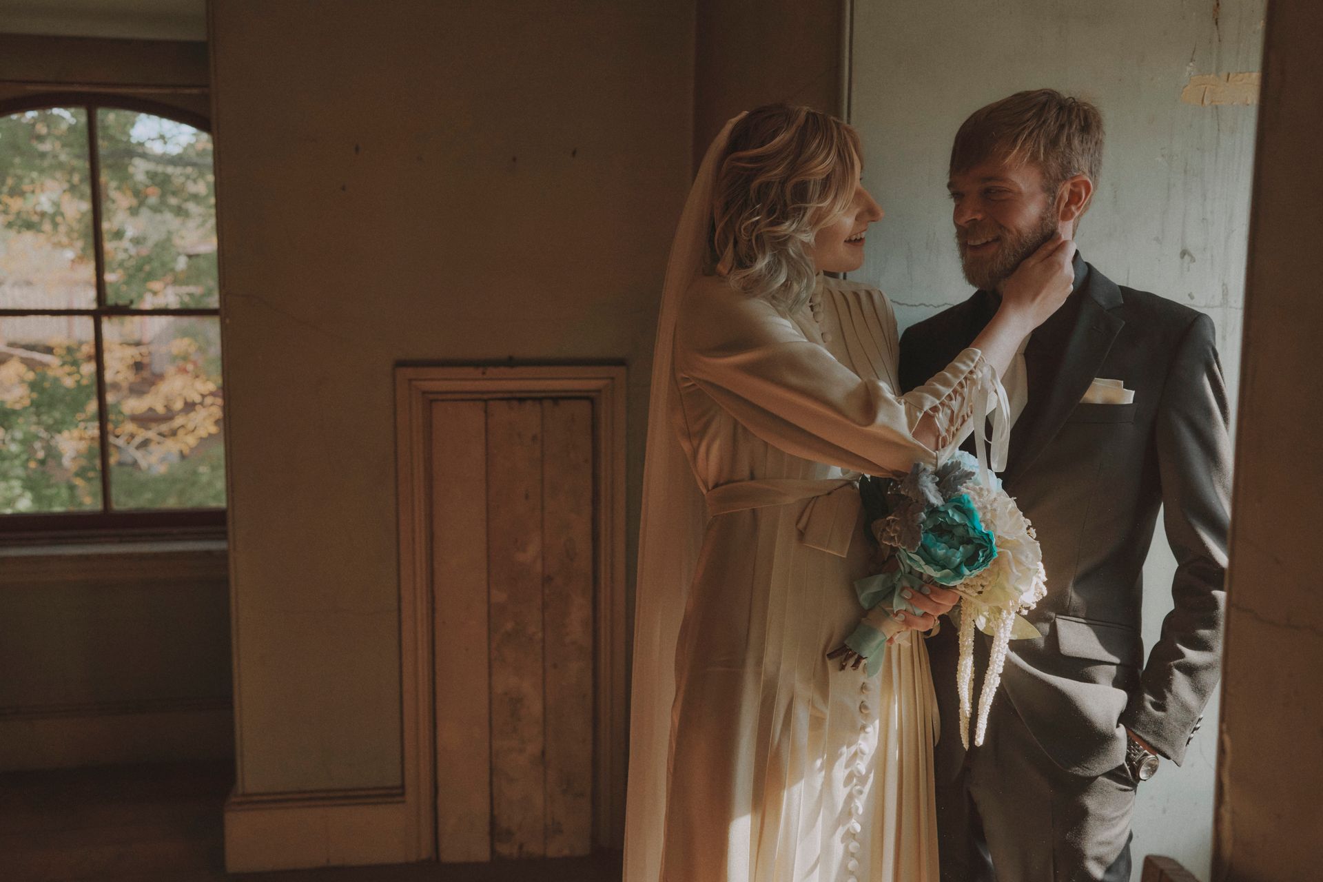 A bride and groom are standing next to each other in a room.