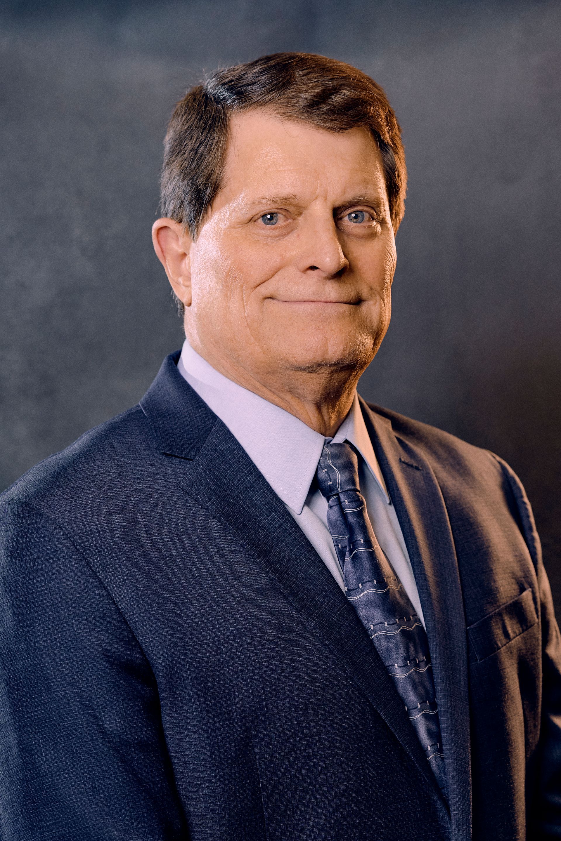 A man in a suit and tie is smiling for the camera.