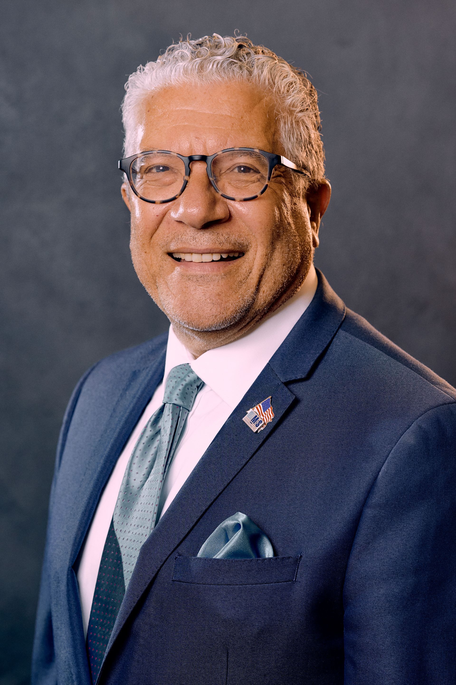 A man in a suit and tie is smiling for the camera.