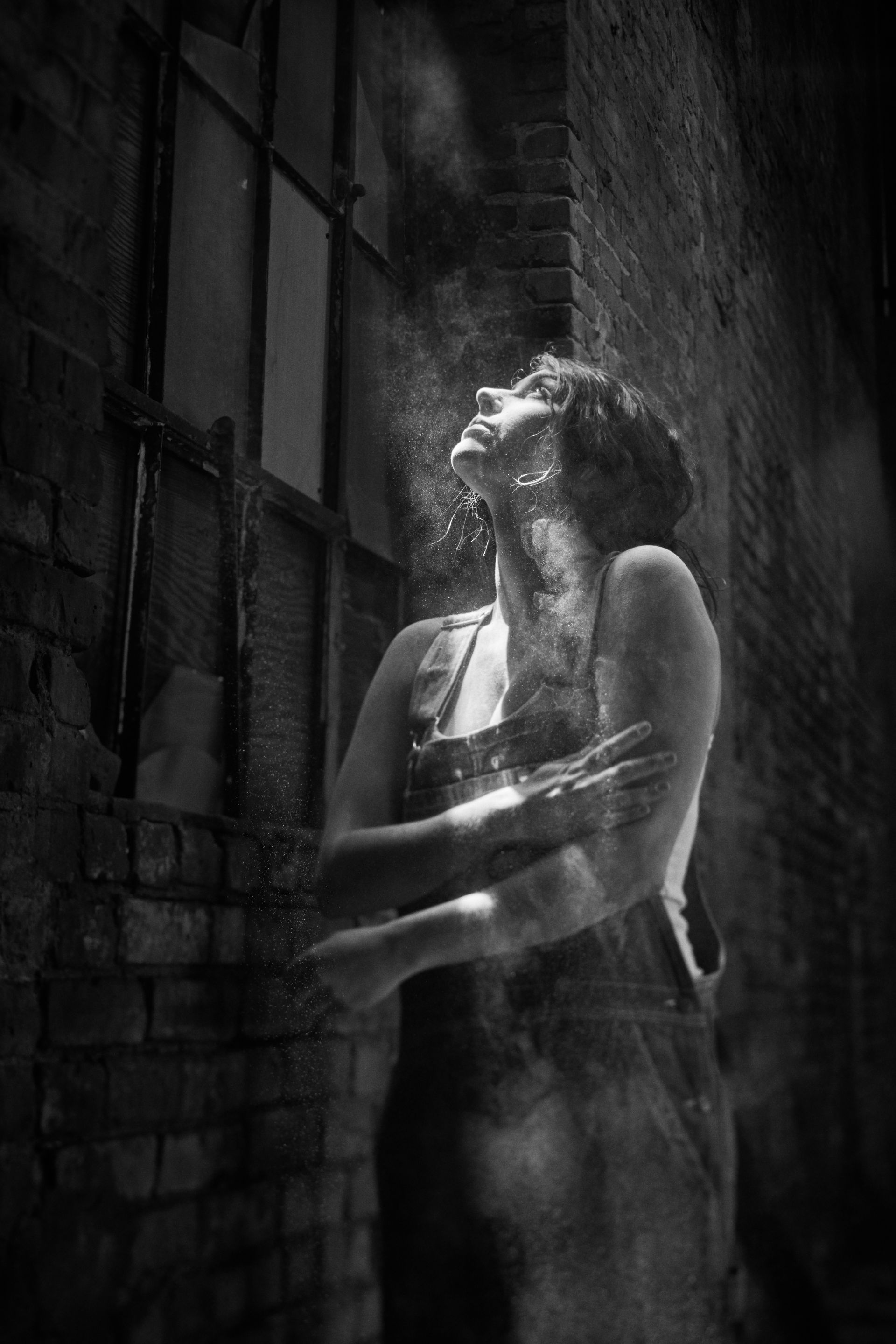 Silhouetted person standing before a bright window in a dark, smoky room