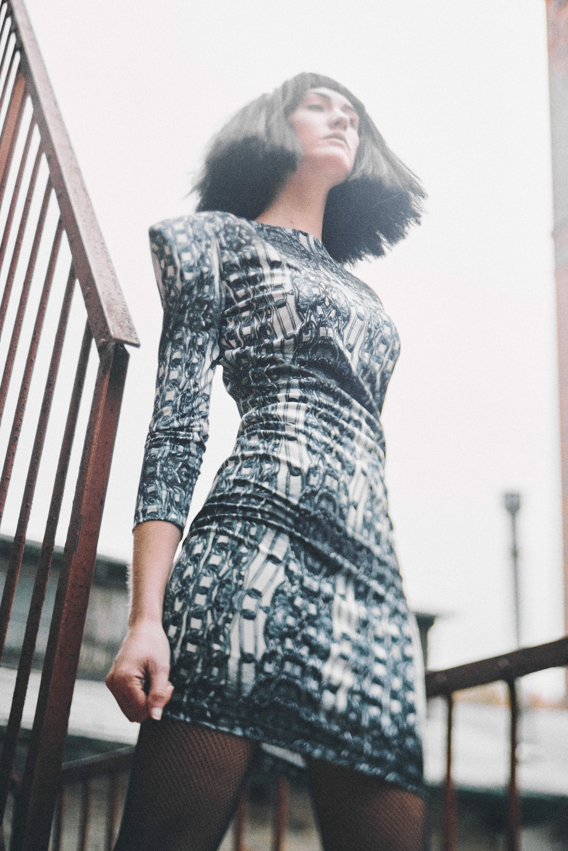 A woman in a dress is standing on a set of stairs.