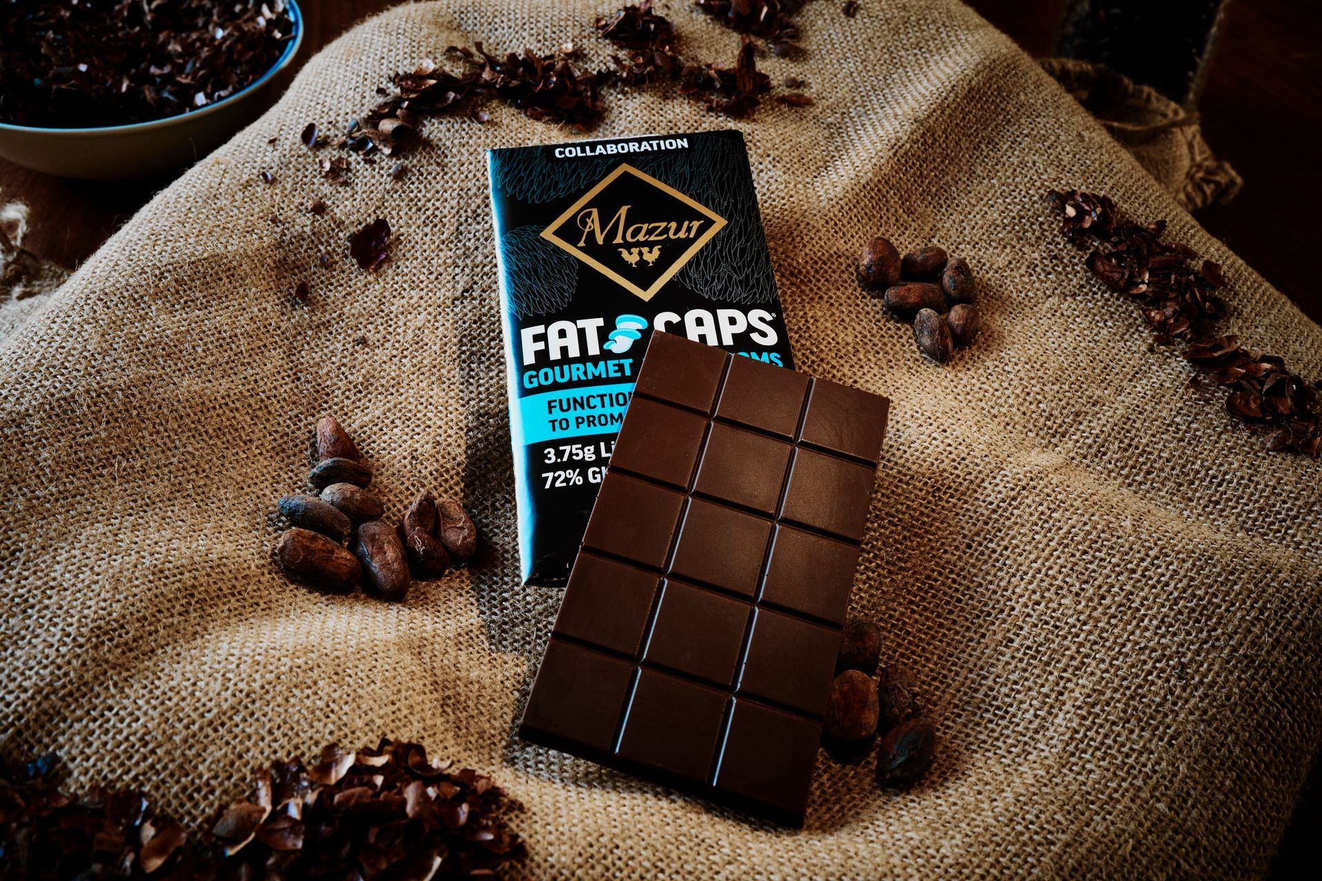A bar of chocolate is sitting on a table next to a box of chocolate.