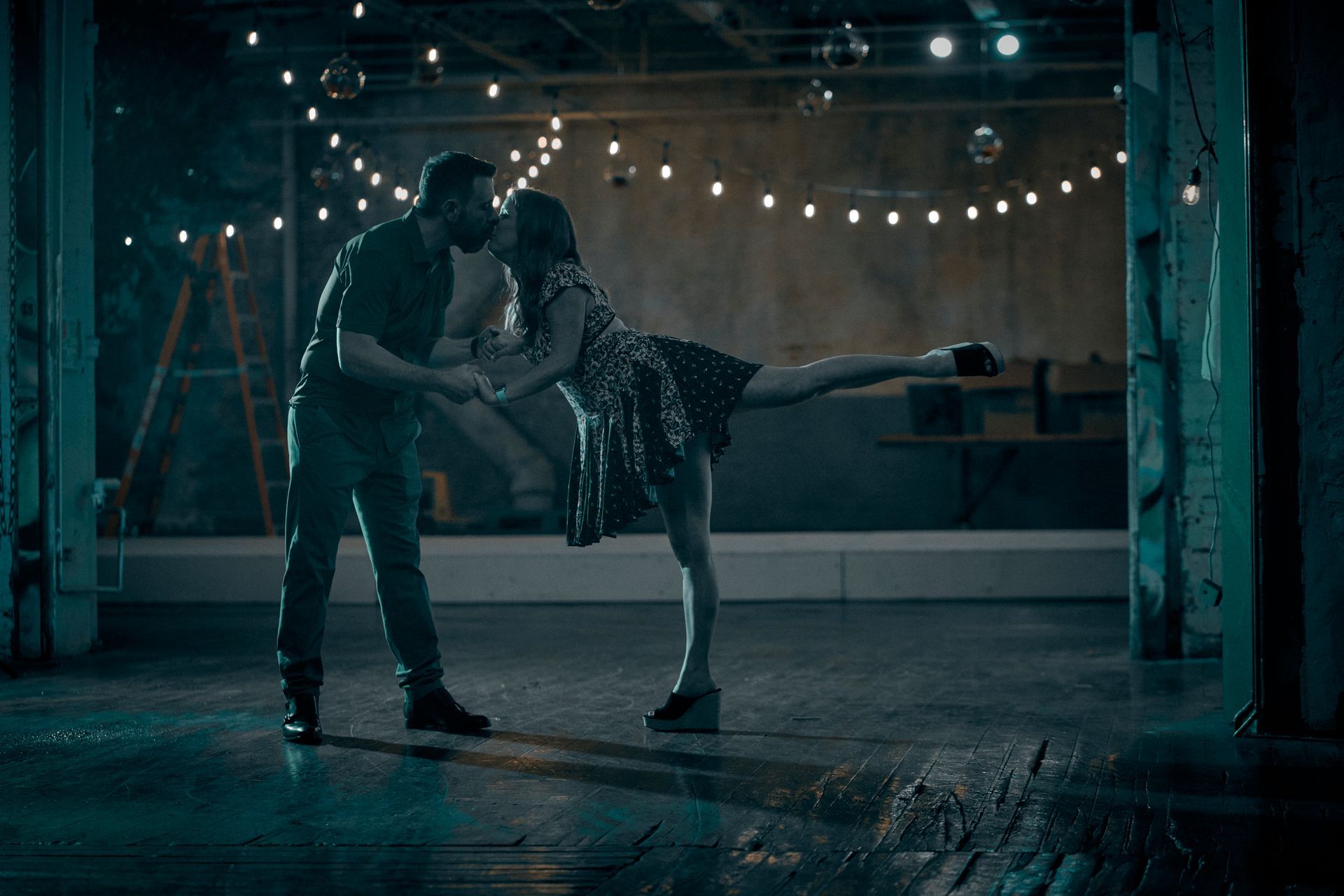 A man and a woman are dancing in a dark room.
