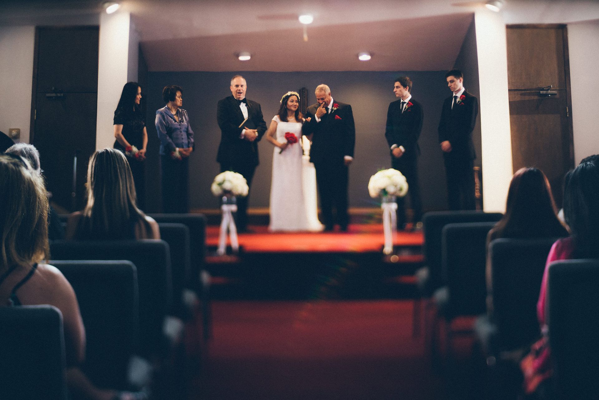 A bride and groom are getting married in front of a crowd of people in a church.