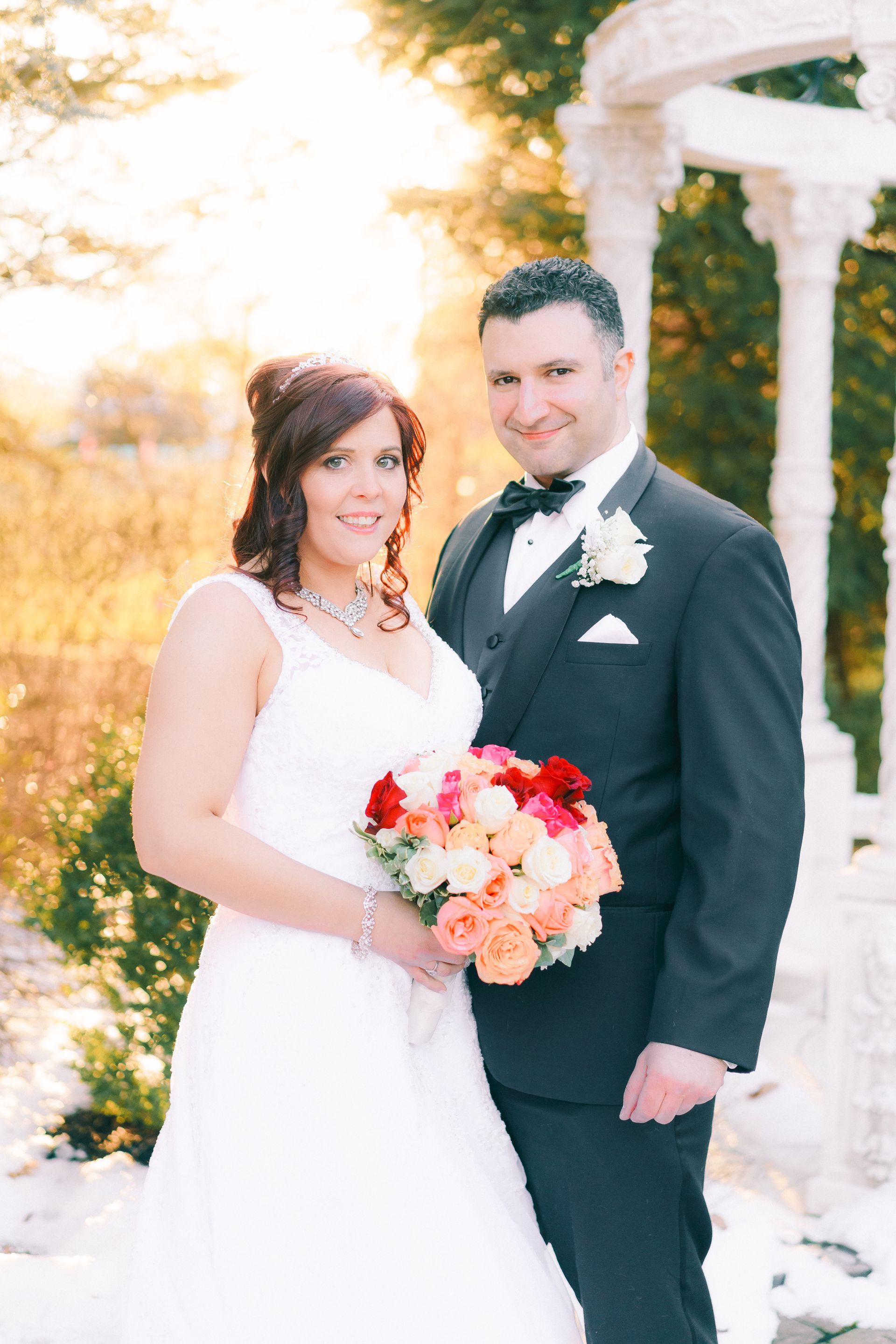 A bride and groom are posing for a picture in front of a gazebo.
