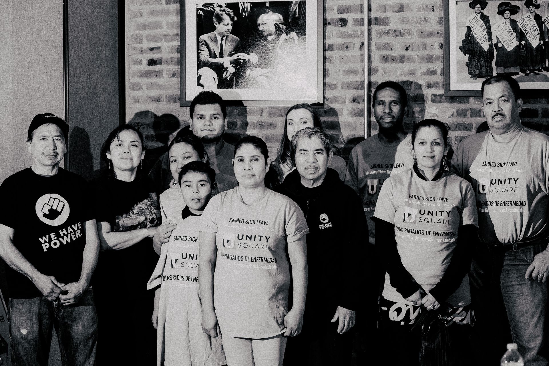A black and white photo of a group of people wearing shirts that say unity