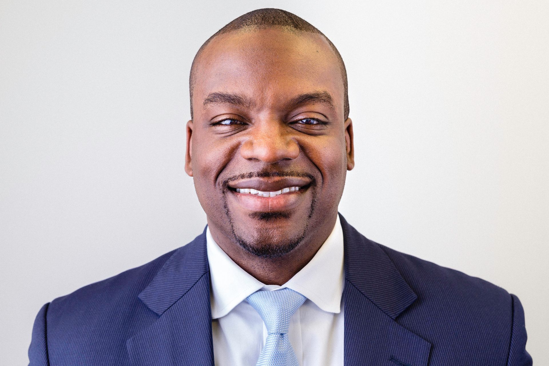 A man in a suit and tie is smiling for the camera.