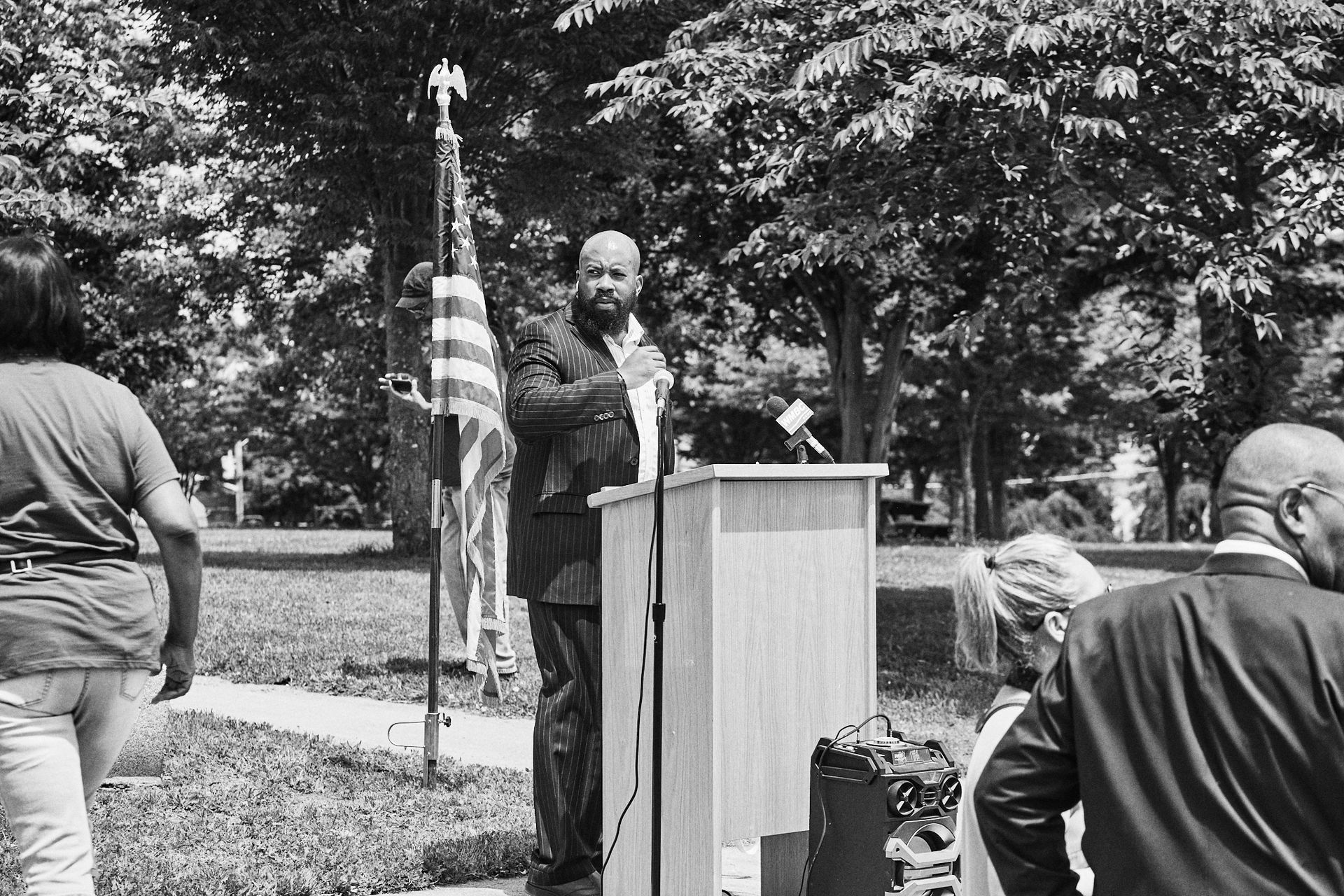 A black and white photo of a man standing at a podium giving a speech dedicated the former Commercial Avenue in New Brunswick as the newly minted Paul Robeson Boulevard.