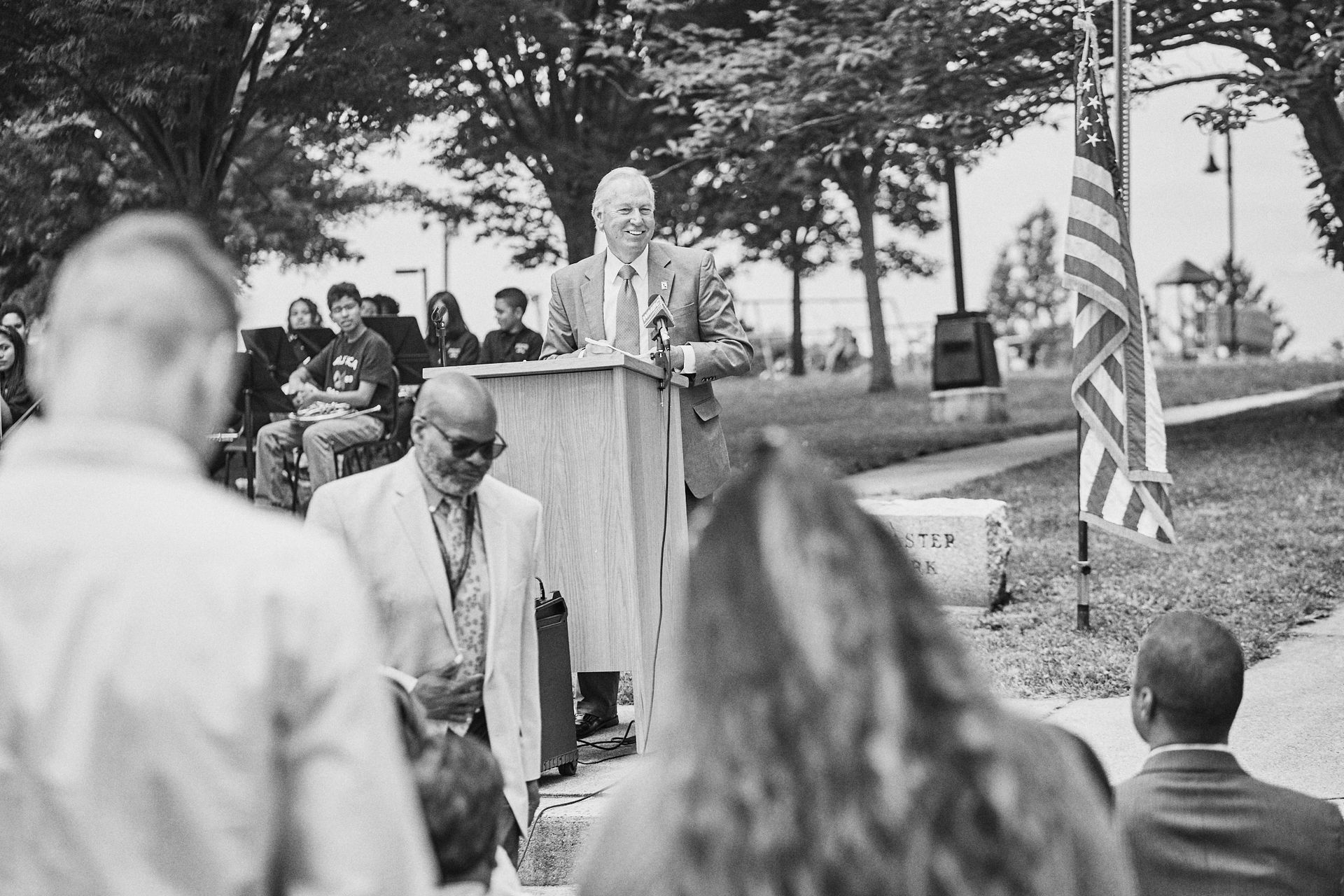A man is standing at a podium giving a speech to a crowd of people.