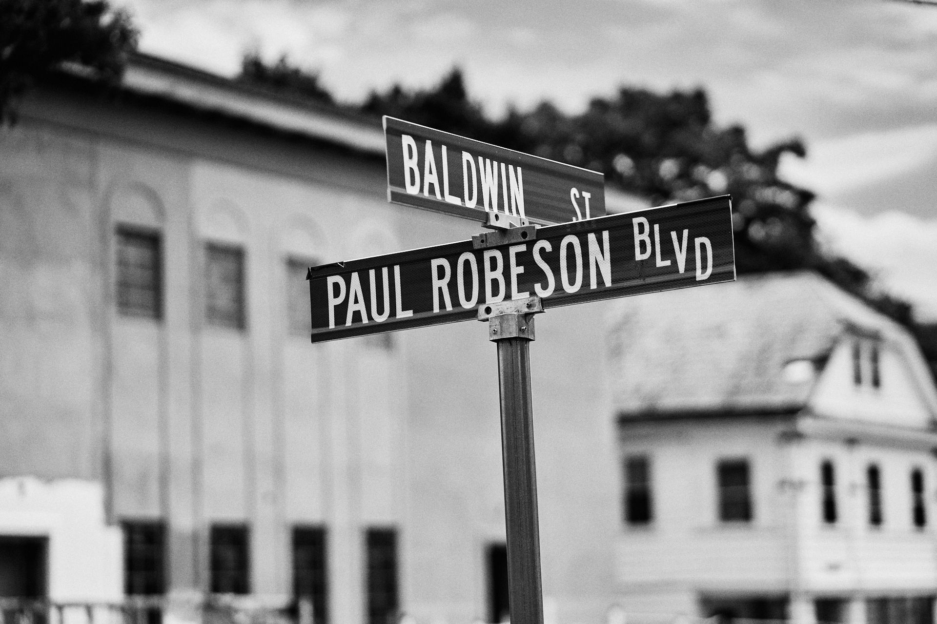 A black and white photo of a street sign for paul robeson blvd