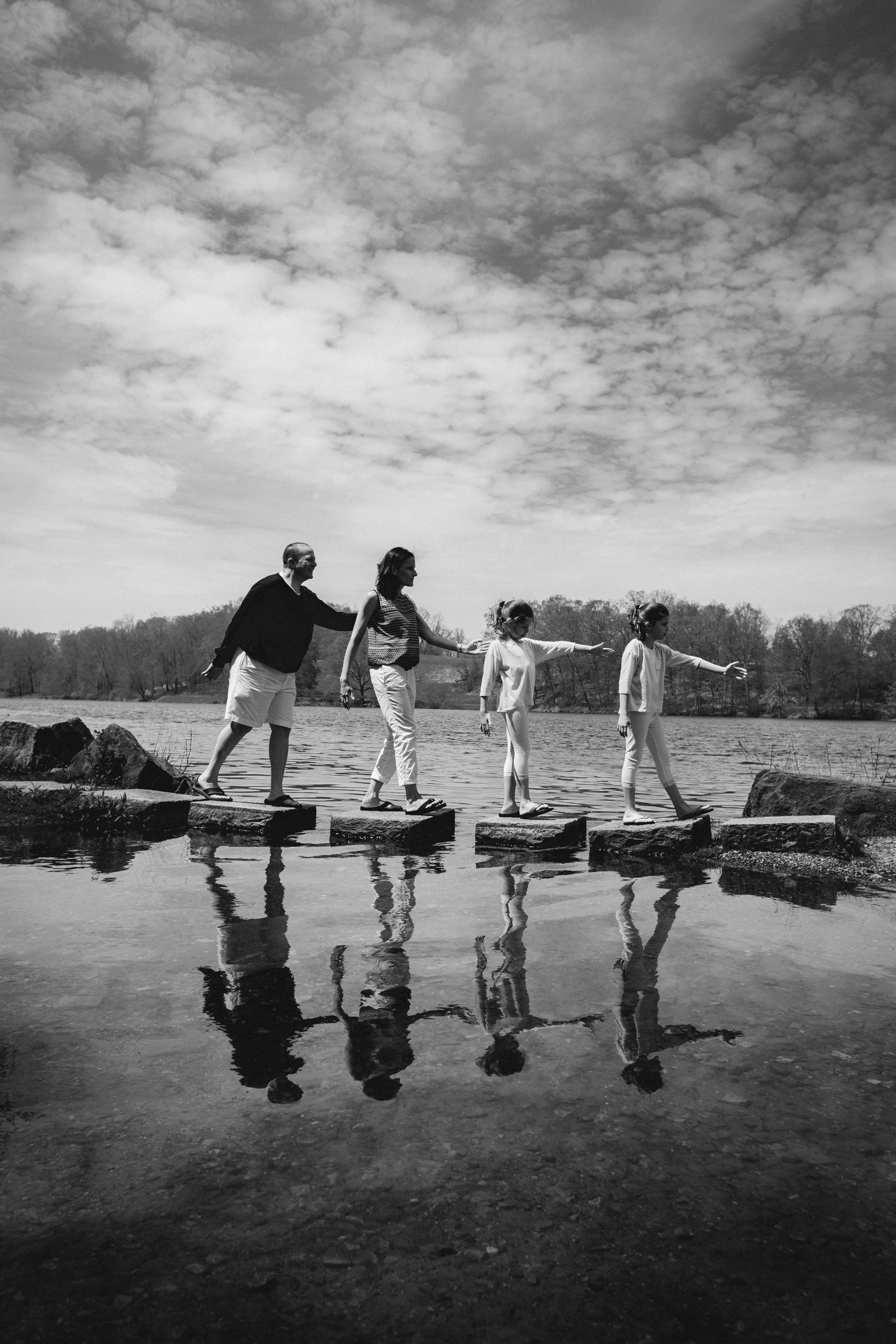 A group of people are standing on rocks in the water.