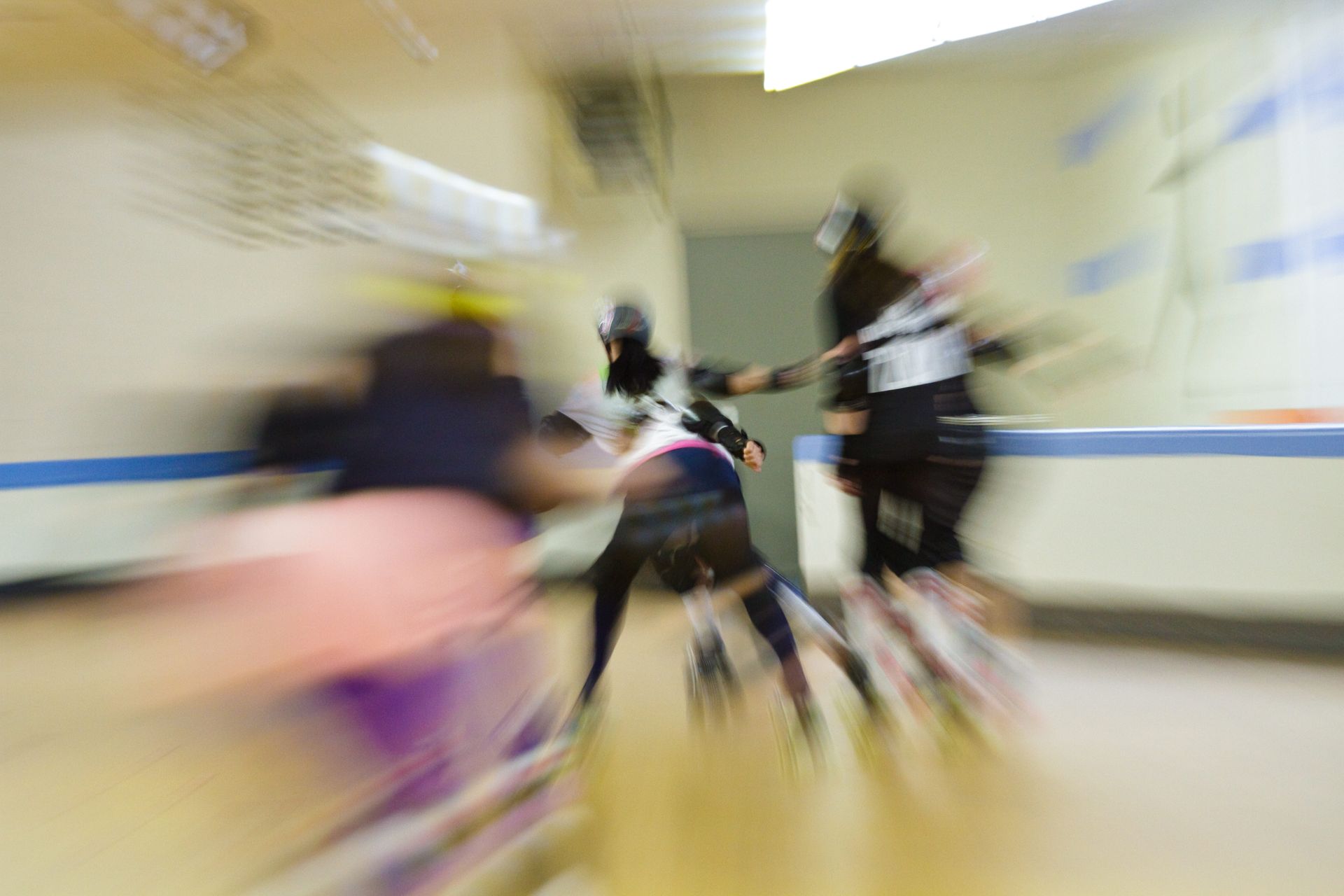 A blurry picture of people rollerblading in a hallway