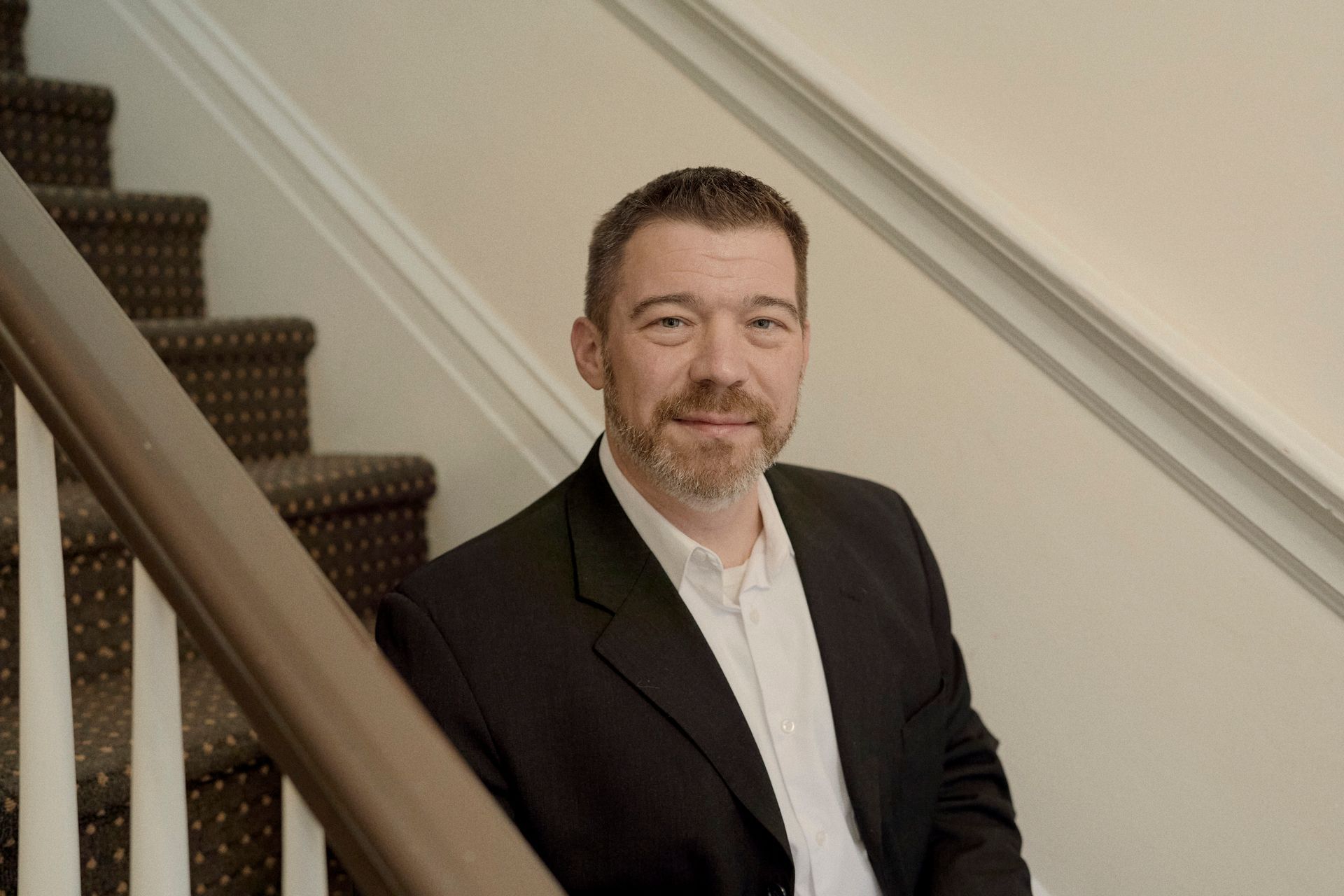 A man in a suit is sitting on a set of stairs.