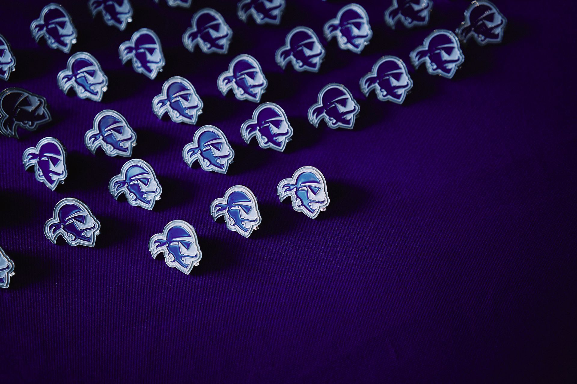 A bunch of earrings are sitting on a purple surface.