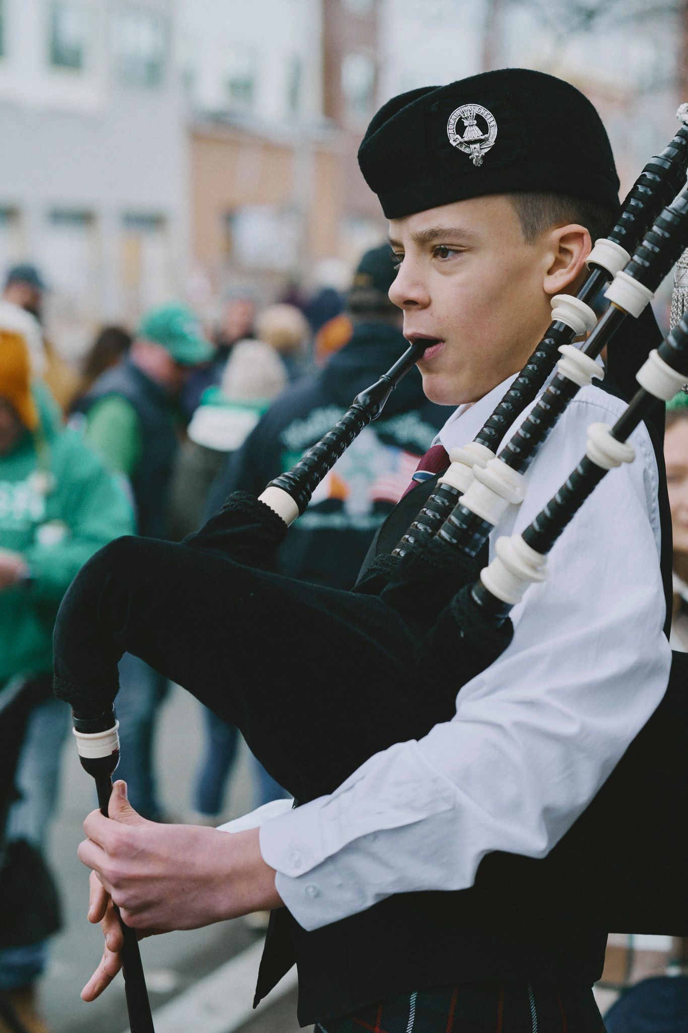 A man is playing a bagpipe in a parade.