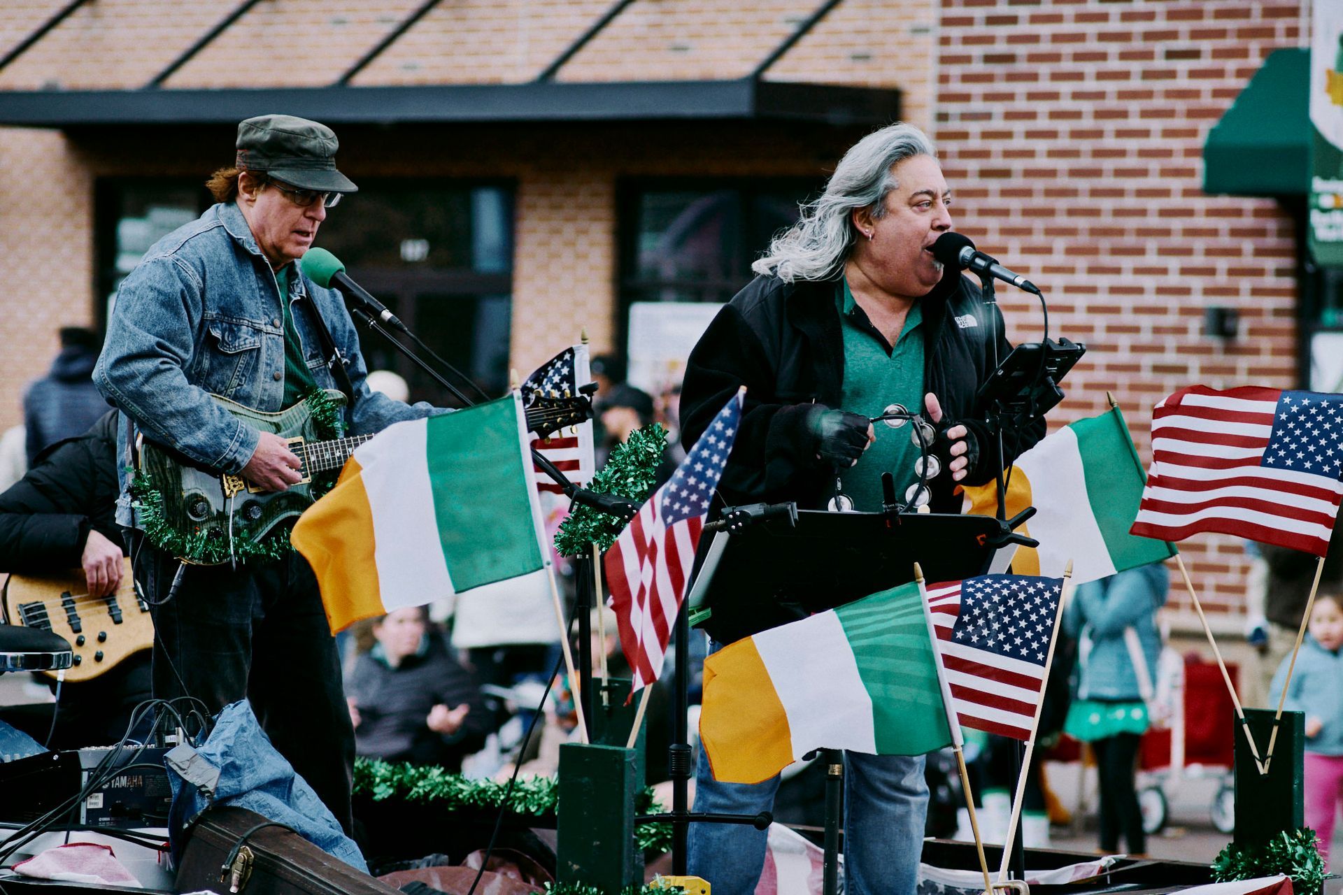 A man is singing into a microphone while another man plays a guitar.