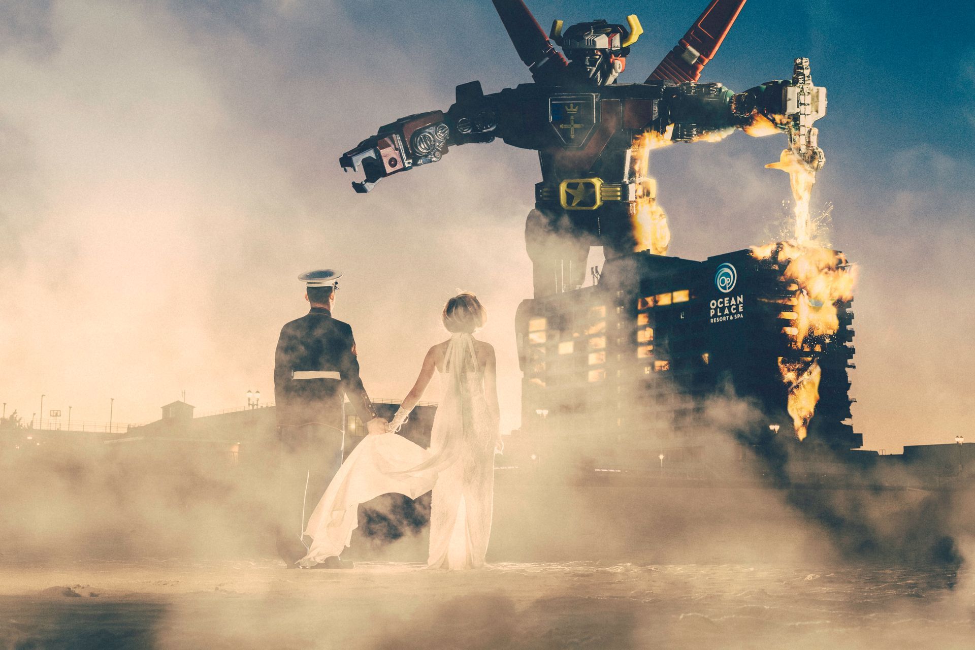 A bride and groom are posing for a picture in front of a robot.