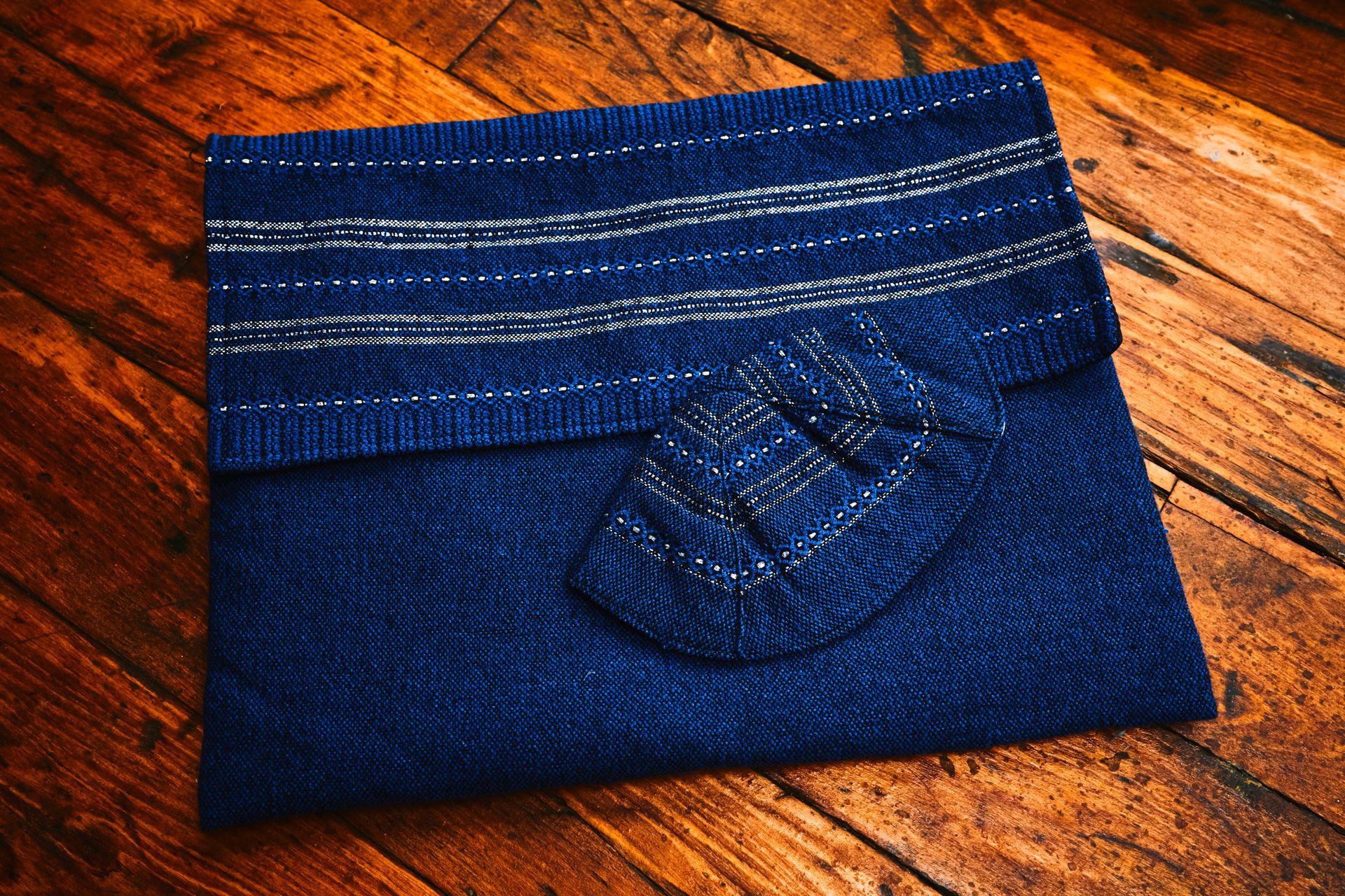 A blue scarf and socks are laying on a wooden table.
