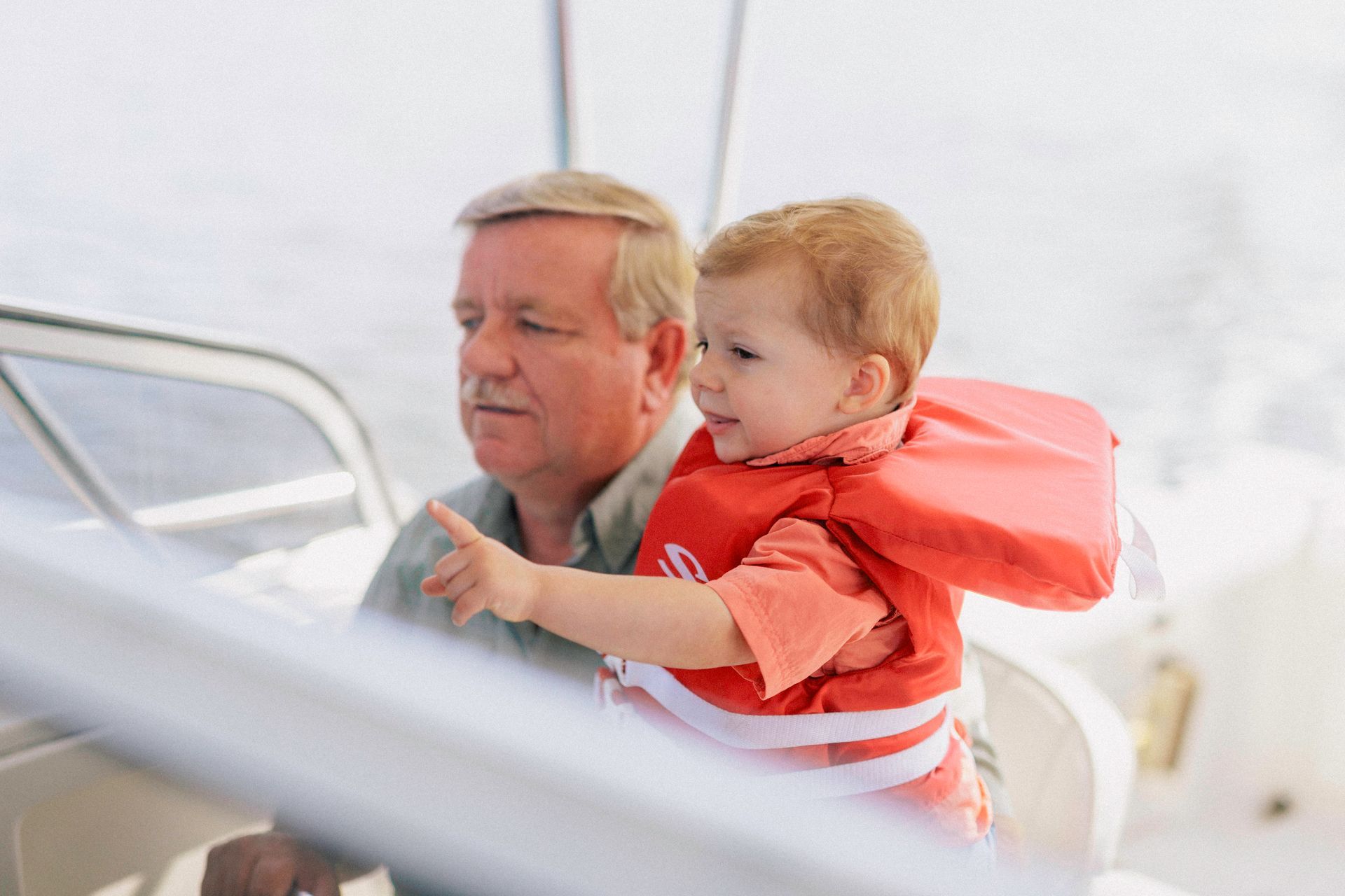 A man is holding a baby in his arms on a boat.