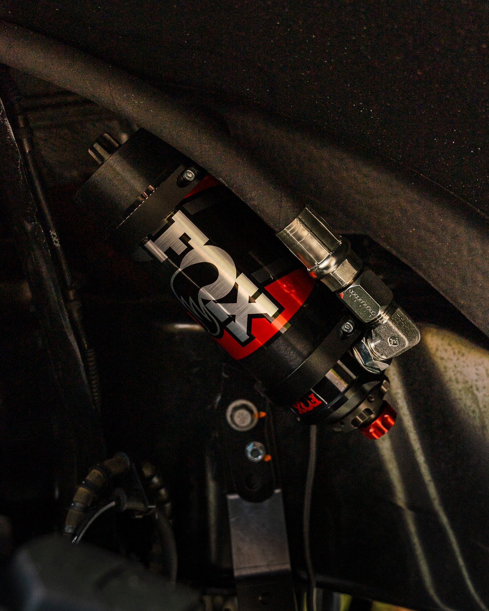 Black and red Fox shock absorber mounted inside a vehicle.
