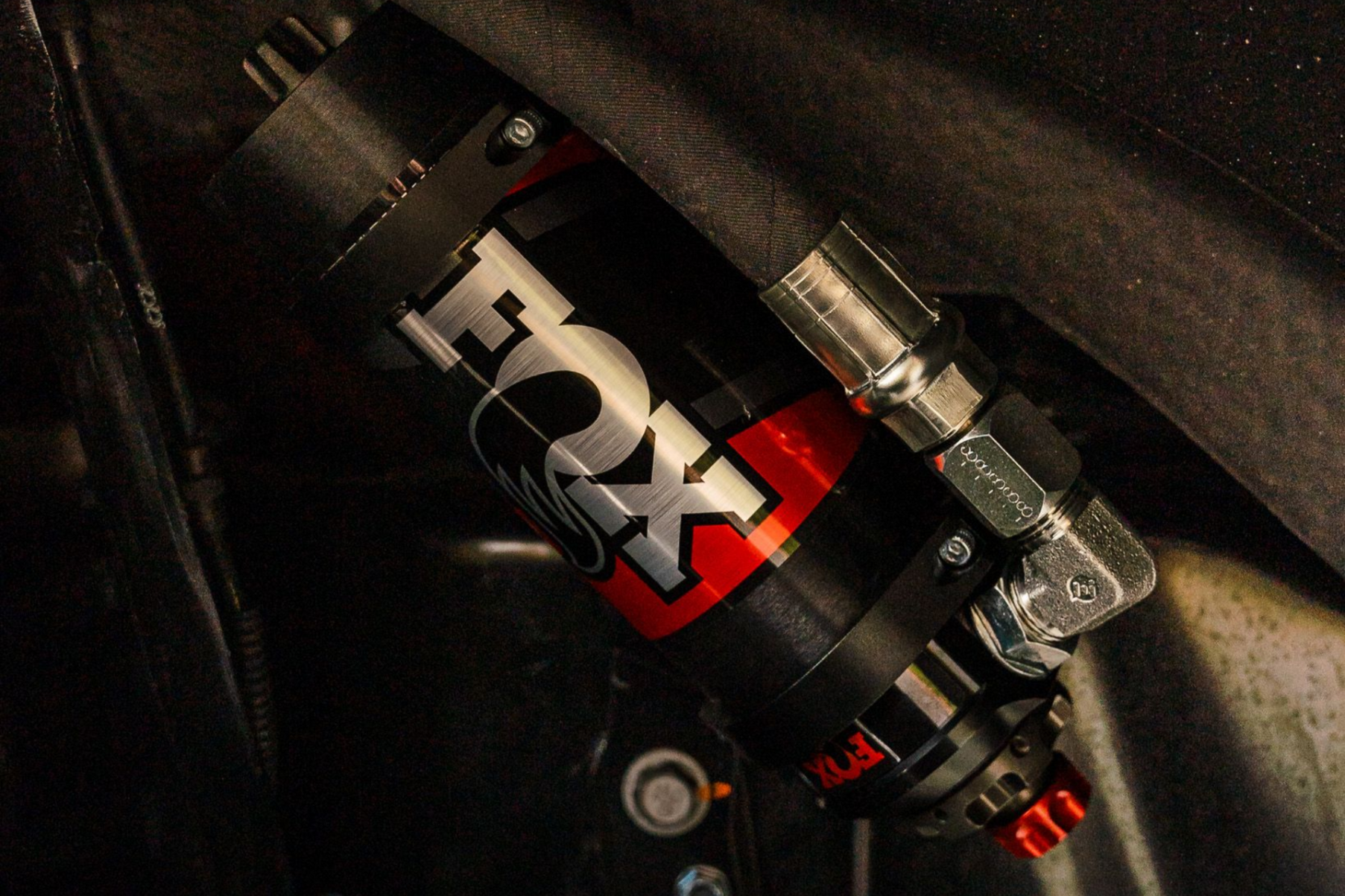 Black and red Fox shock absorber mounted on a vehicle.