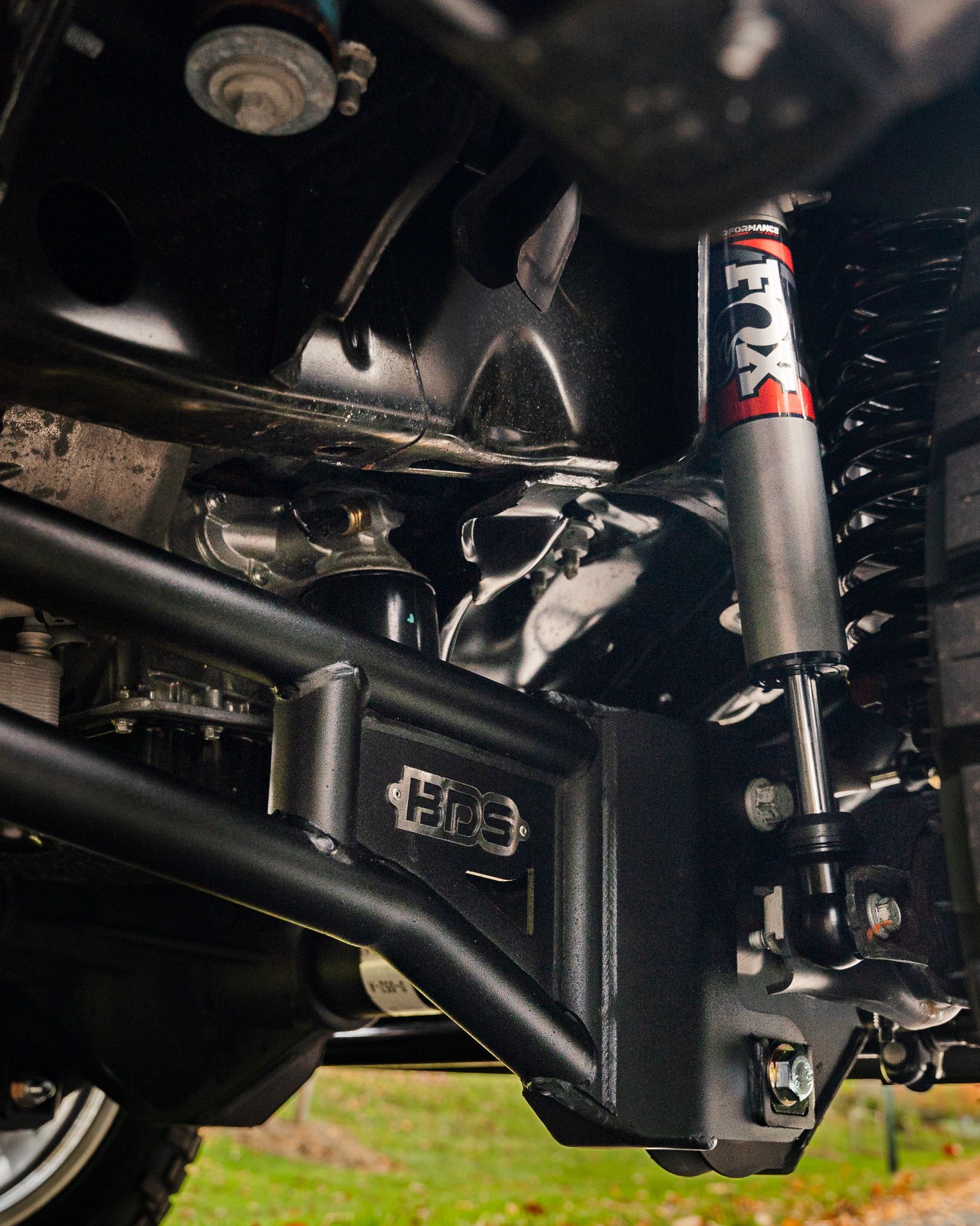Black truck suspension components with a Fox shock absorber.