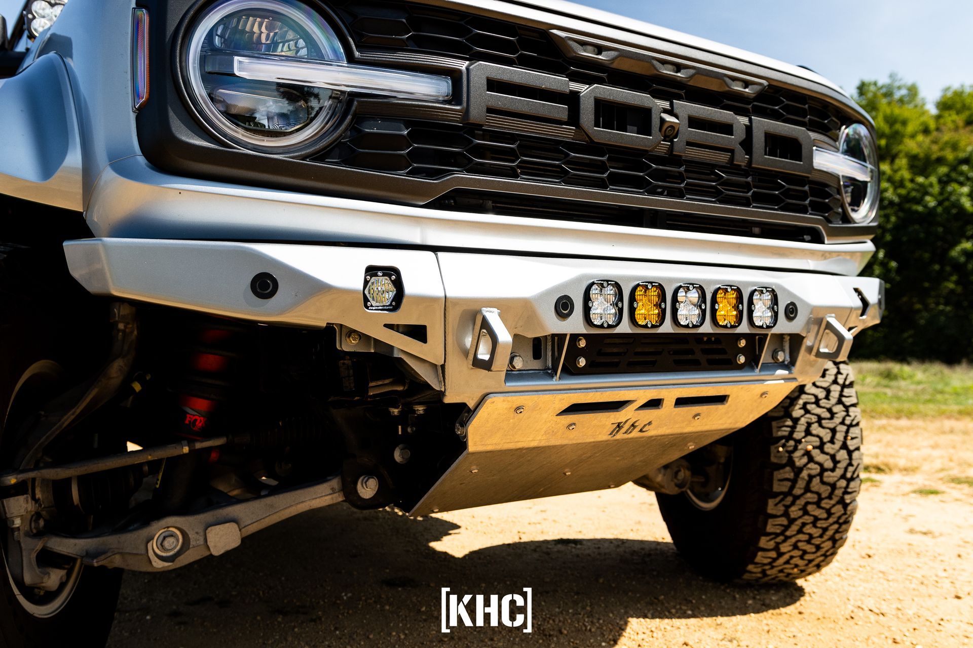 Silver Ford Bronco with custom front bumper and off-road lights.
