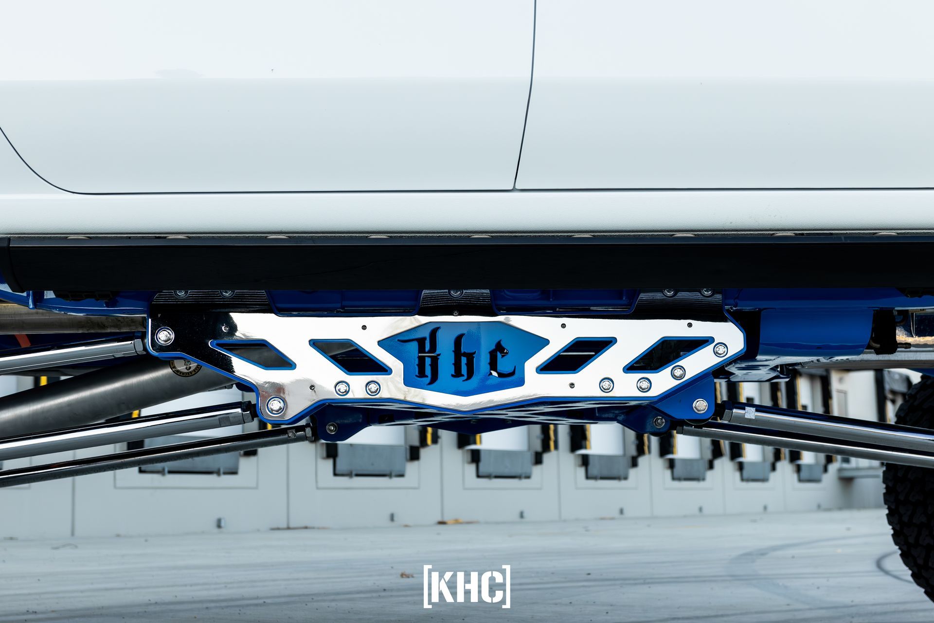 Close-up of a lifted truck suspension, blue and white, with