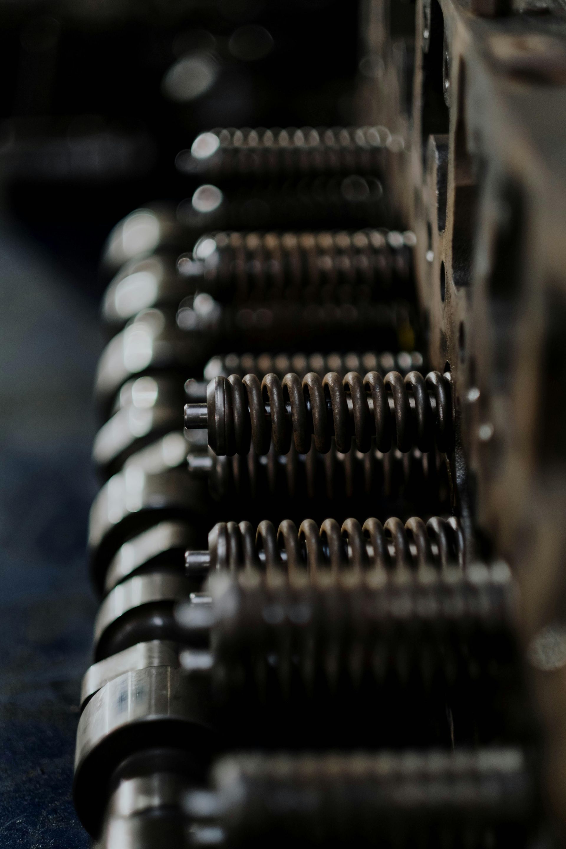 Close-up of engine valve springs, part of a cylinder head, in a mechanical setting.
