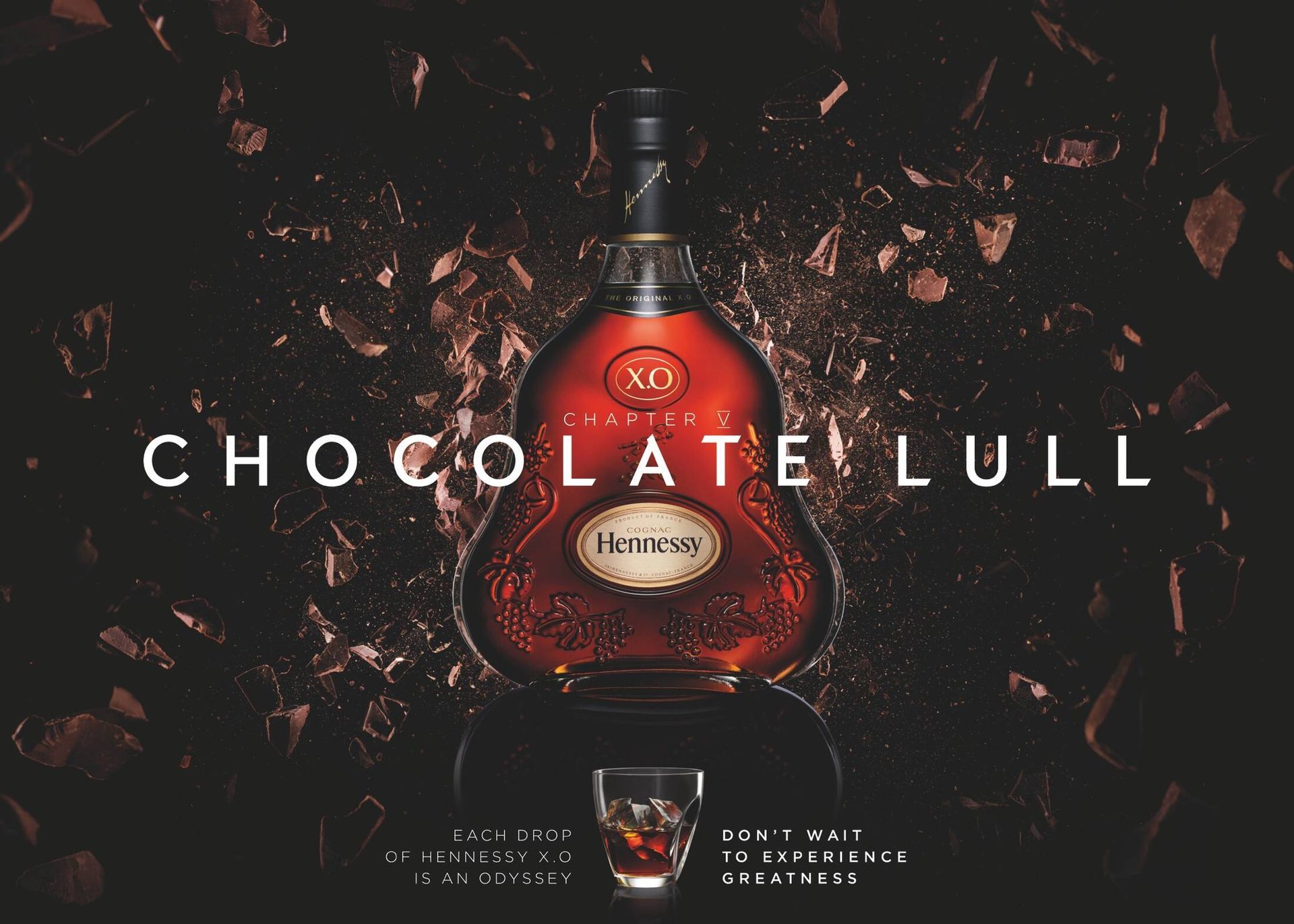 A bottle of hennessy cognac is surrounded by chocolate shavings