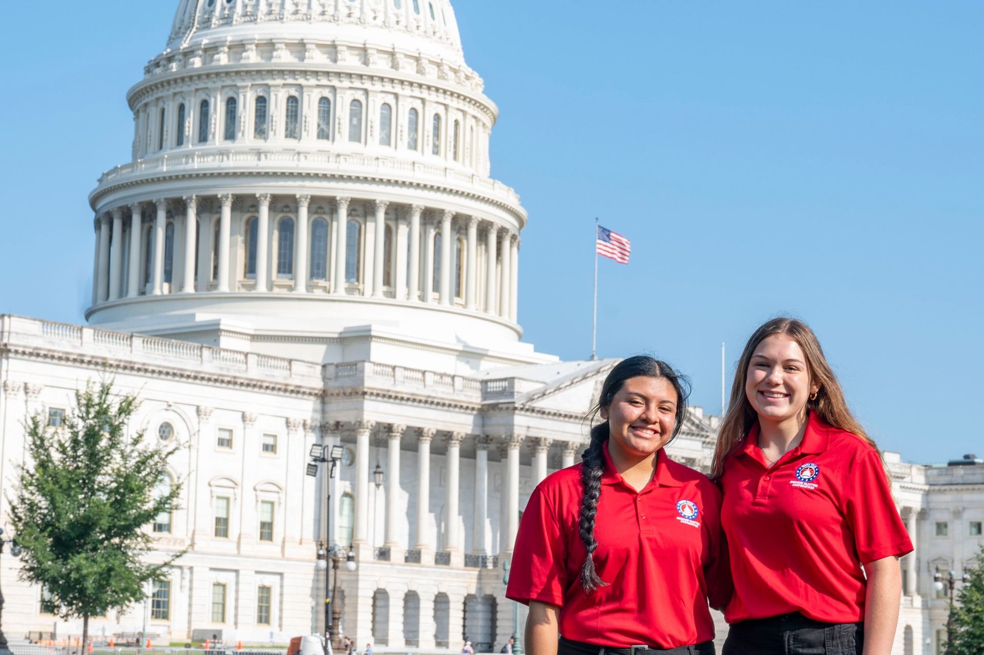 Two young women are standing in front of the capitol building.