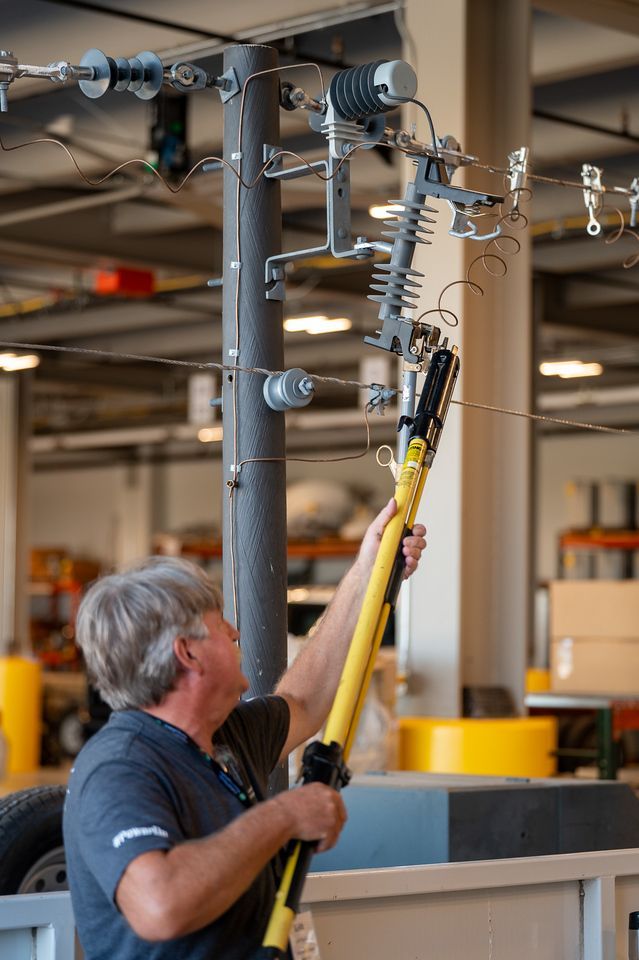 Man showing a fuse holding a hot stick