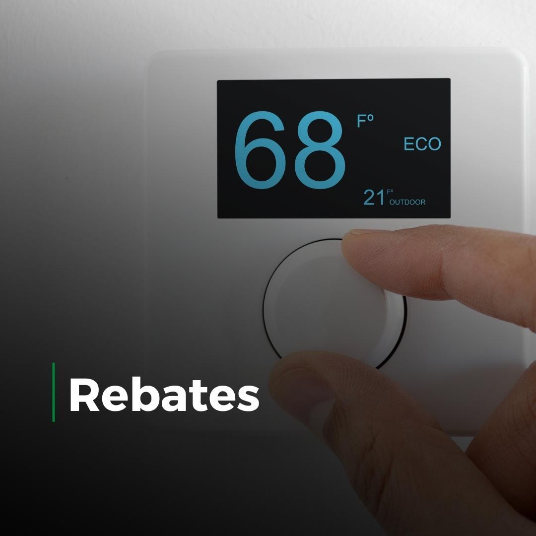 Hand adjusting a white thermostat displaying 68°F, with “Rebates” text on screen