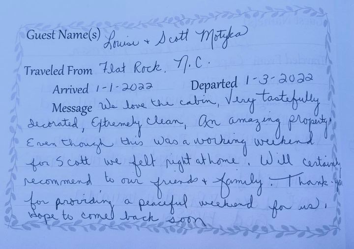 Handwritten guestbook entry on blue paper with black ink text and signatures