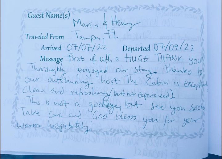 Handwritten guestbook note with names, travel dates, and a thank-you message on white paper