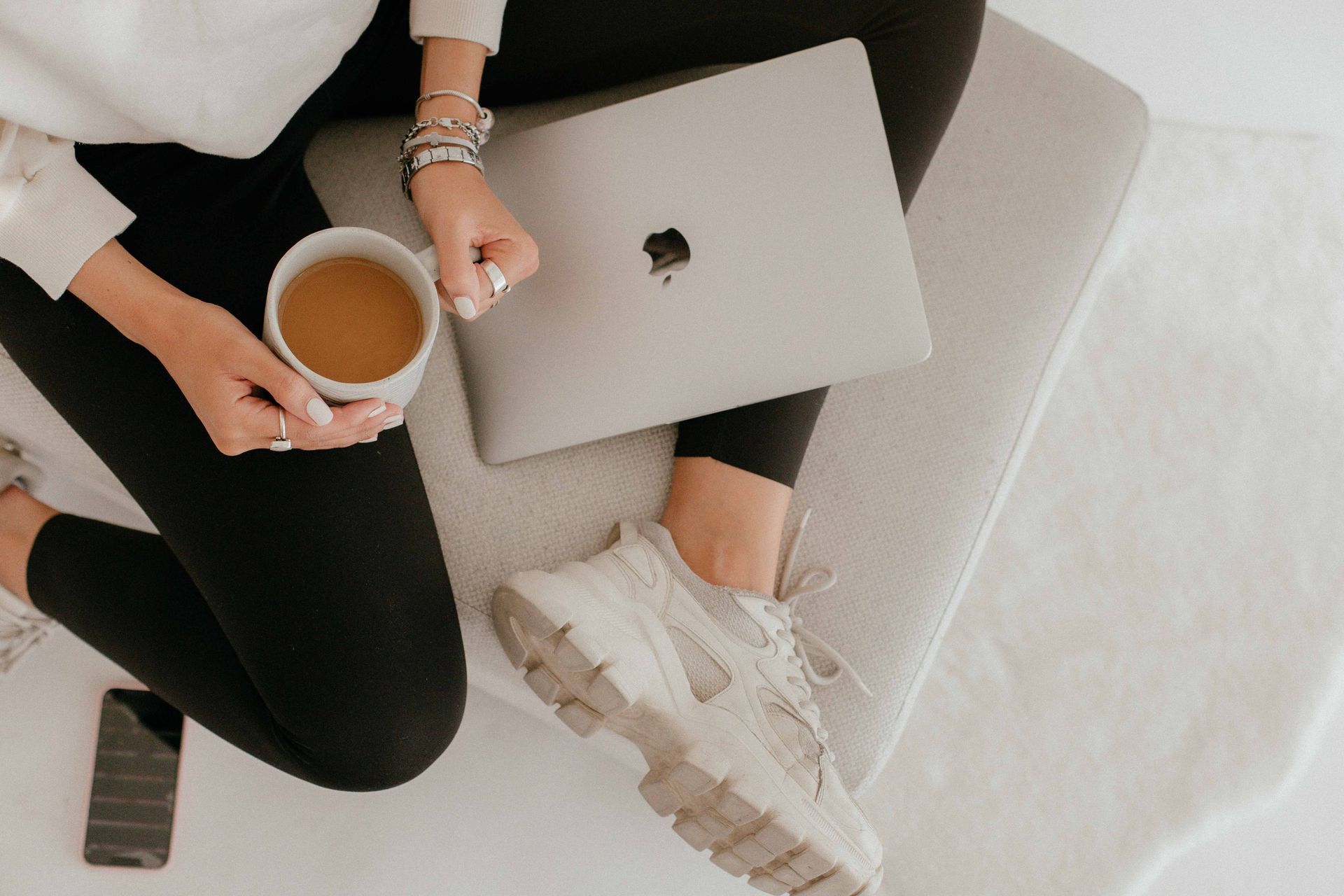 A laptop on a wooden desk beside a window in a calm home office