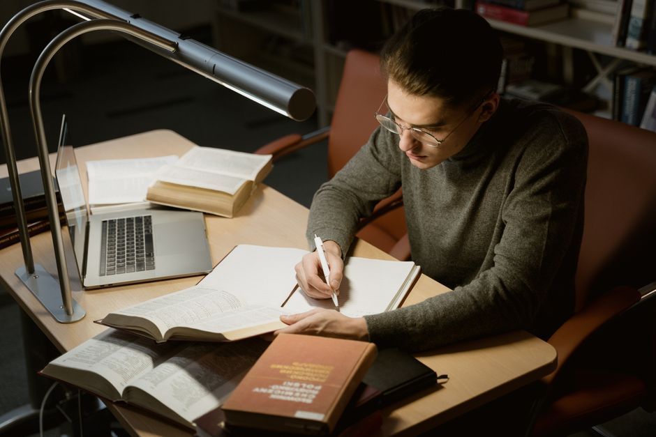 Printed pages, reading glasses, and a pen arranged on a clean desk