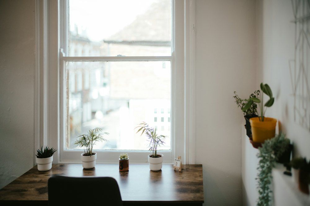 Wooden desk and chair beside a window in a quiet, light filled home office