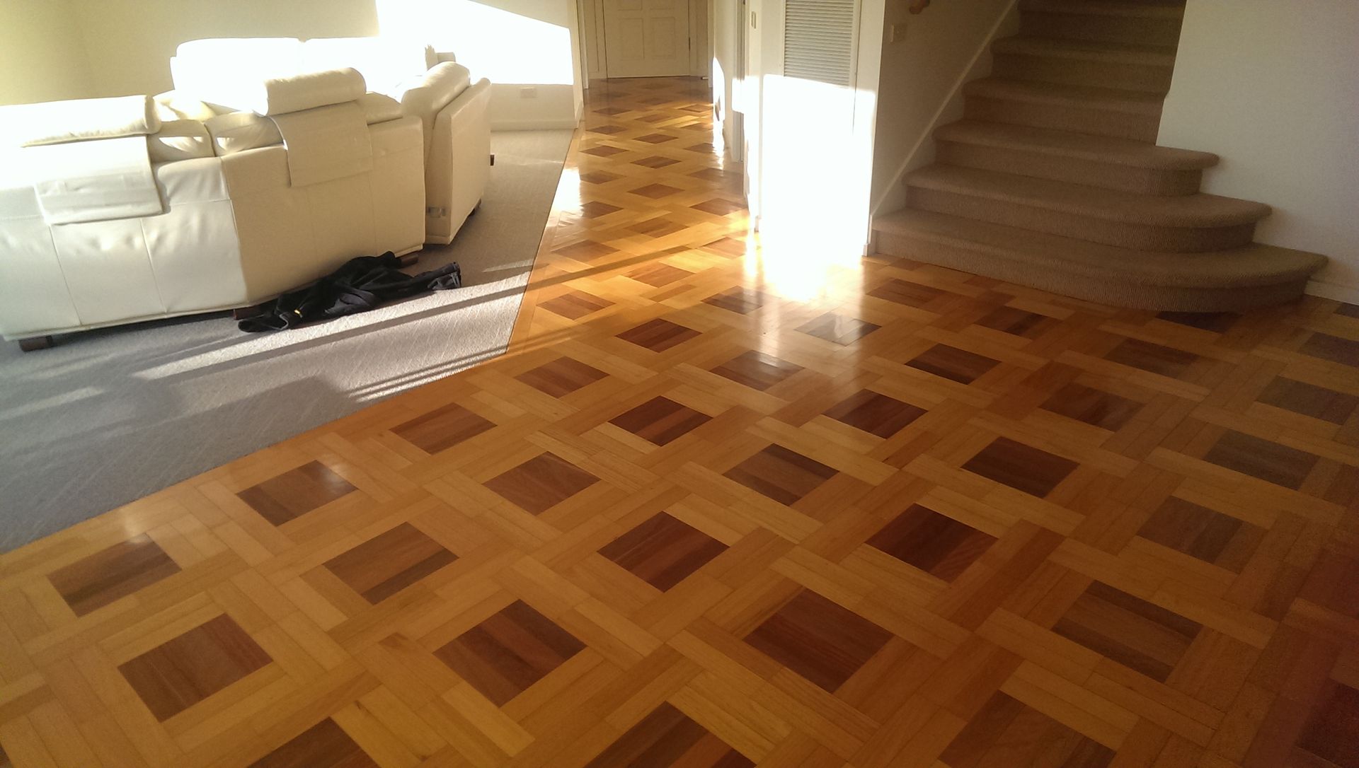 A living room with hardwood floors and a rug on the floor