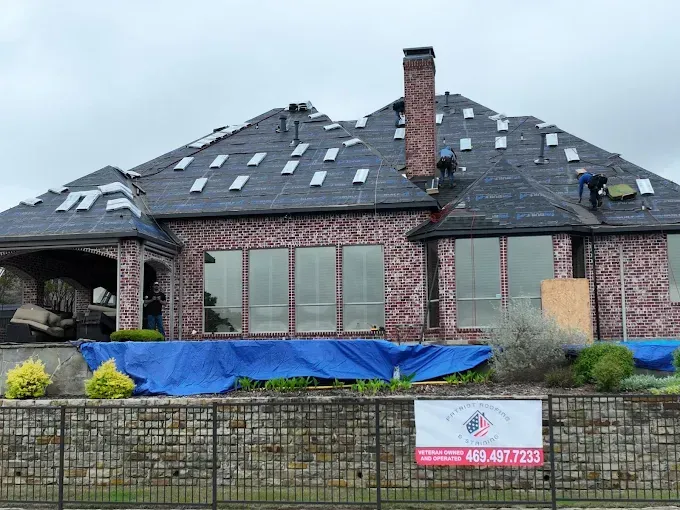 A brick house with a roof that is being repaired.