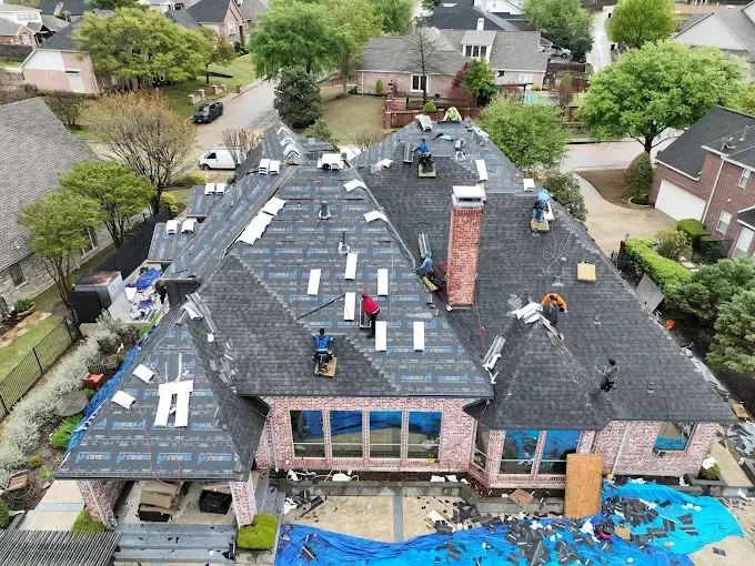 An aerial view of a roof being installed on a large house.