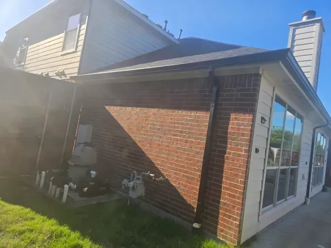 A brick house with a lot of windows and a chimney.