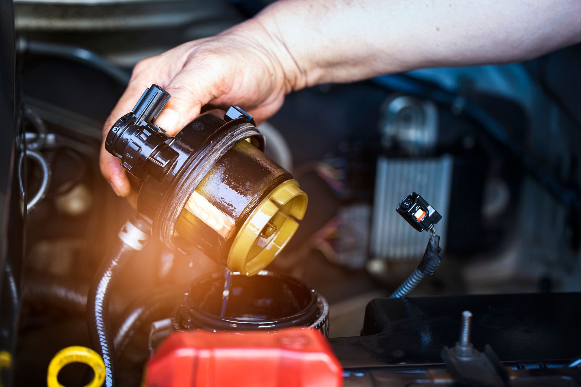 A person is pouring oil into a car engine.