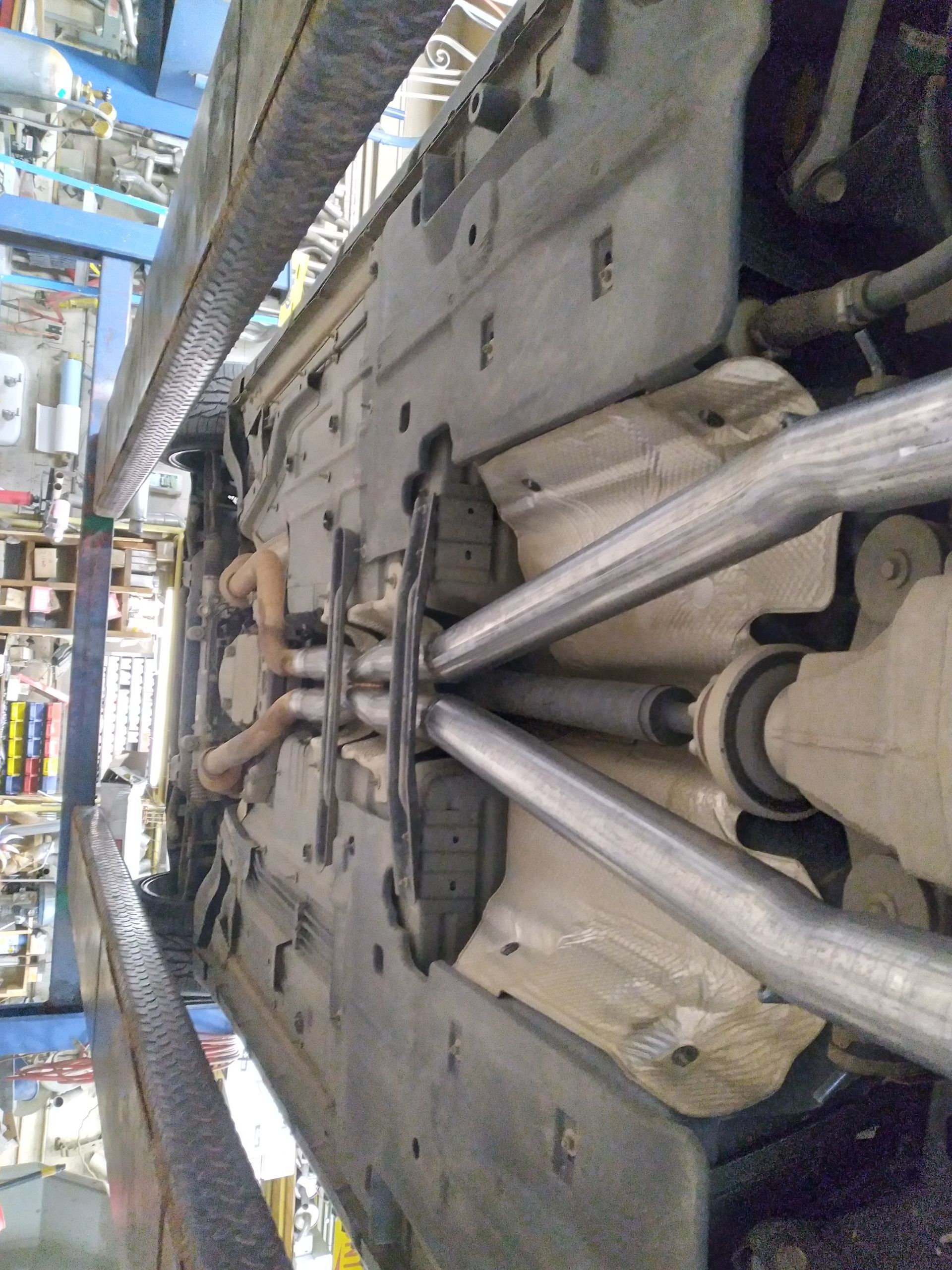 A close up of the underside of a car in a garage.