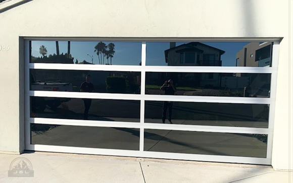 Reflective garage door with white horizontal panels on a suburban house.